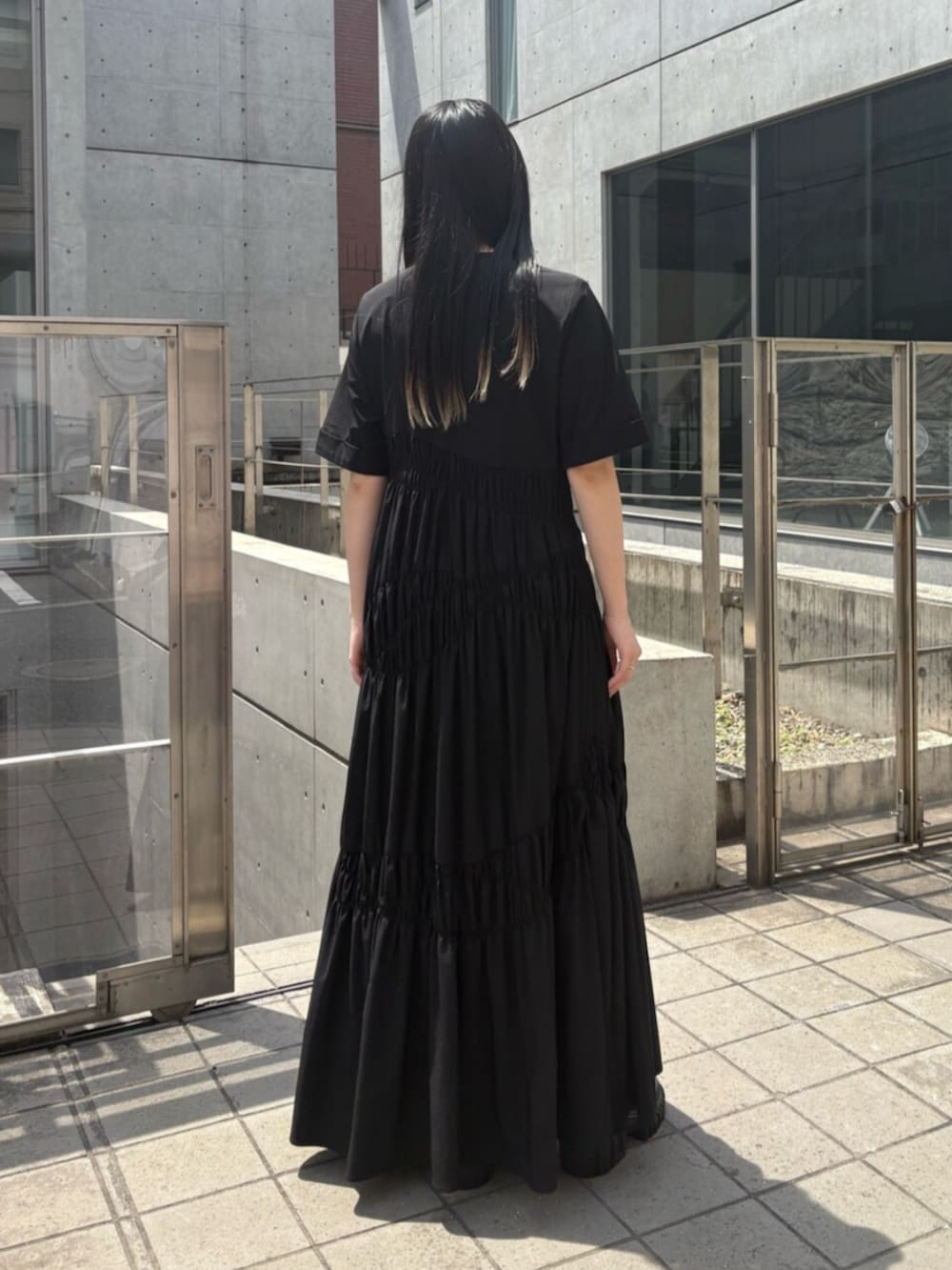 ブラック系のサンダル、ブラック系のワンピースを着用したレディースの夏コーディネートの3枚目の写真