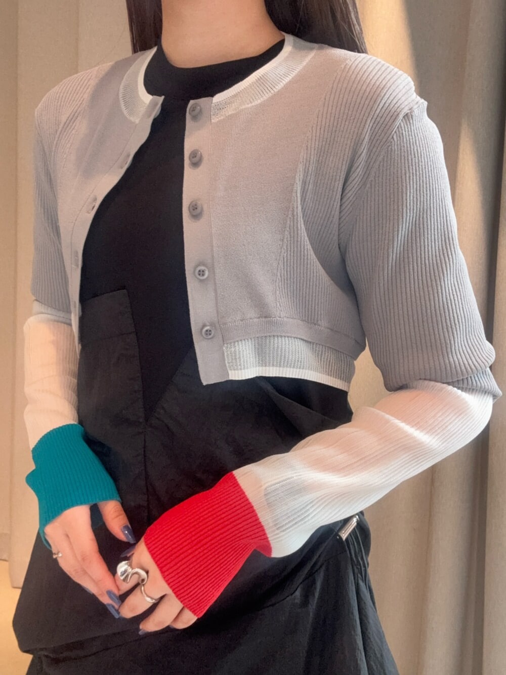 シルバー系のブーツ、ブラック系のワンピース、グレー系のカーディガン/ボレロを着用したレディースの春コーディネートの5枚目の写真