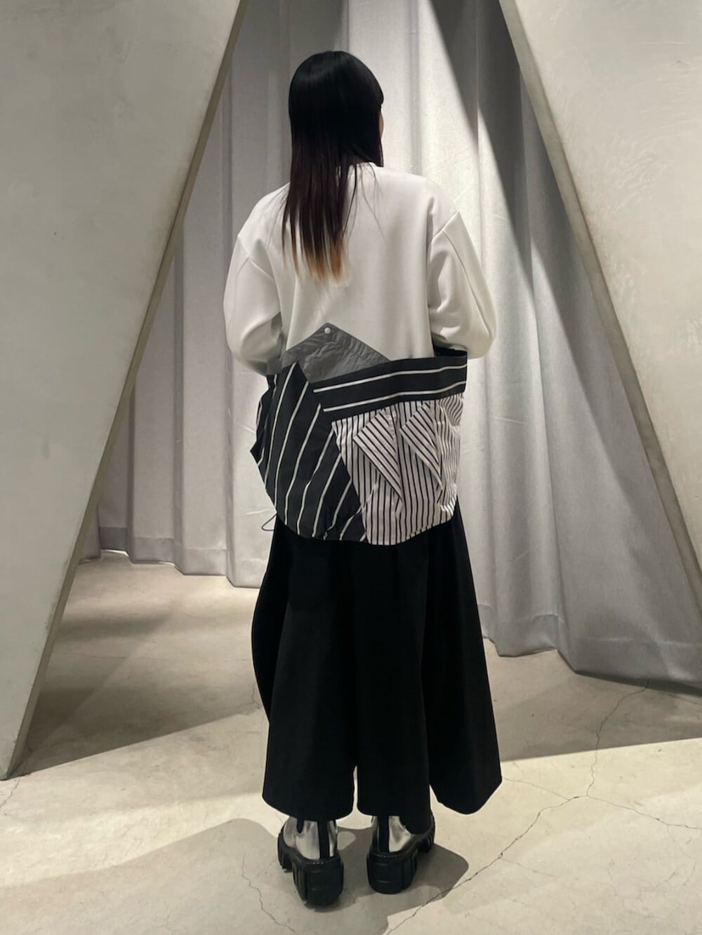 ブラック系のスカート、シルバー系のブーツ、その他のTシャツ/カットソーを着用したレディースの冬コーディネートの3枚目の写真