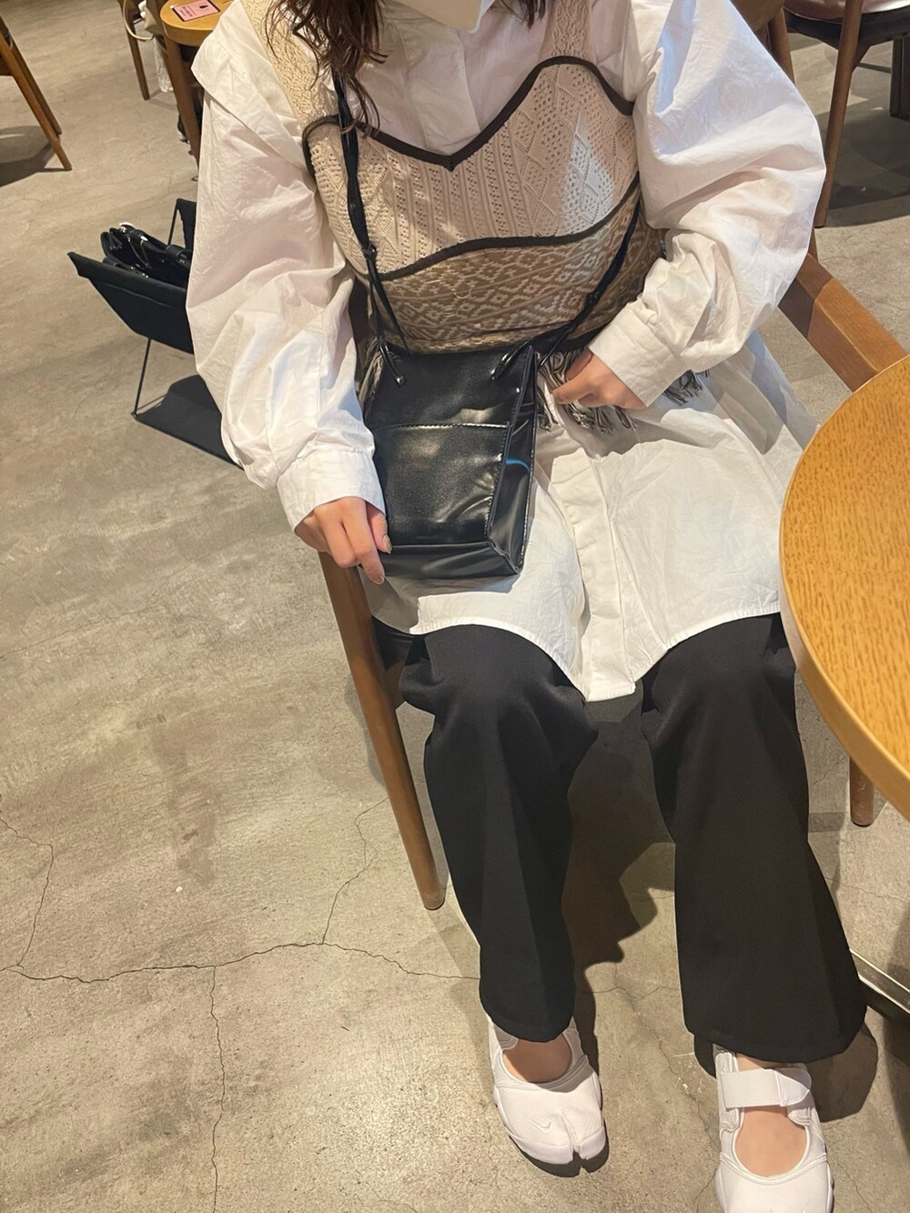 ベージュ系のベスト、ブラック系のショルダーバッグ、ホワイト系のシャツ/ブラウスを着用したレディースの春コーディネートの2枚目の写真