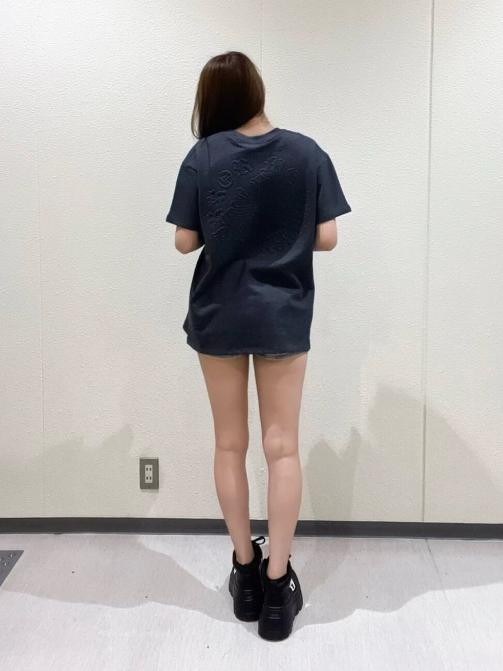 ブラック系のハンドバッグ、グレー系のTシャツ/カットソー、ブラック系のスニーカーを着用したレディースの夏コーディネートの3枚目の写真