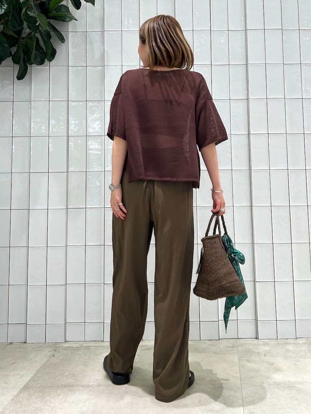 ブラウン系のその他パンツ、ブラウン系のニット/セーター、ブラウン系のかごバッグを着用したレディースの春コーディネートの4枚目の写真