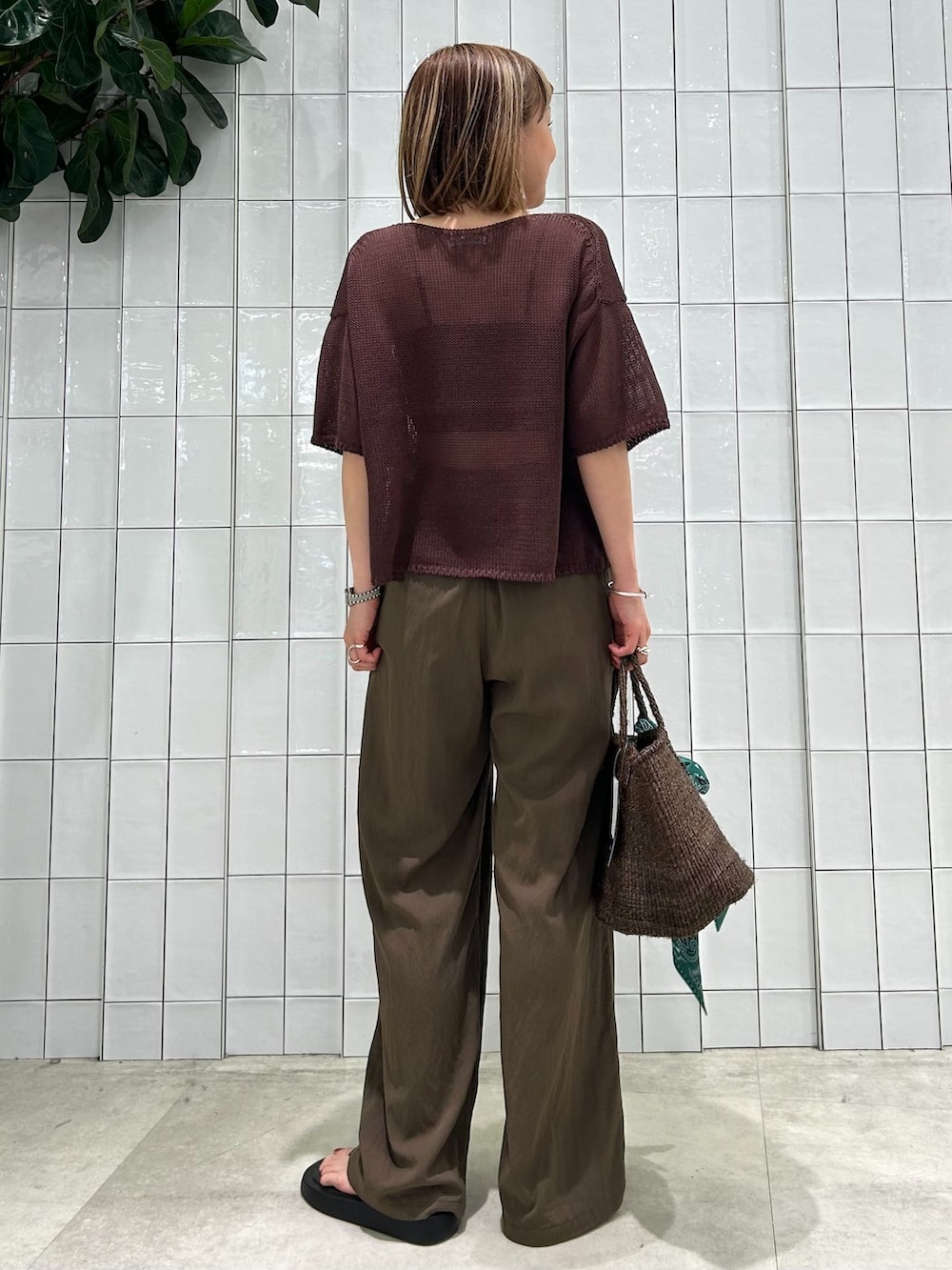 ブラウン系のその他パンツ、ブラウン系のニット/セーター、ブラウン系のかごバッグを着用したレディースの春コーディネートの5枚目の写真