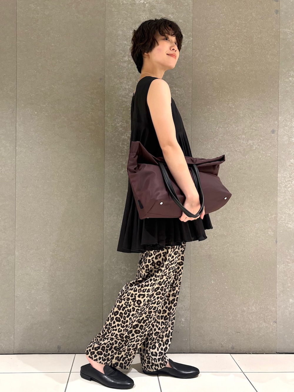 ベージュ系のその他パンツ、ブラック系のシャツ/ブラウス、レッド系のトートバッグを着用したレディースの夏コーディネートの2枚目の写真