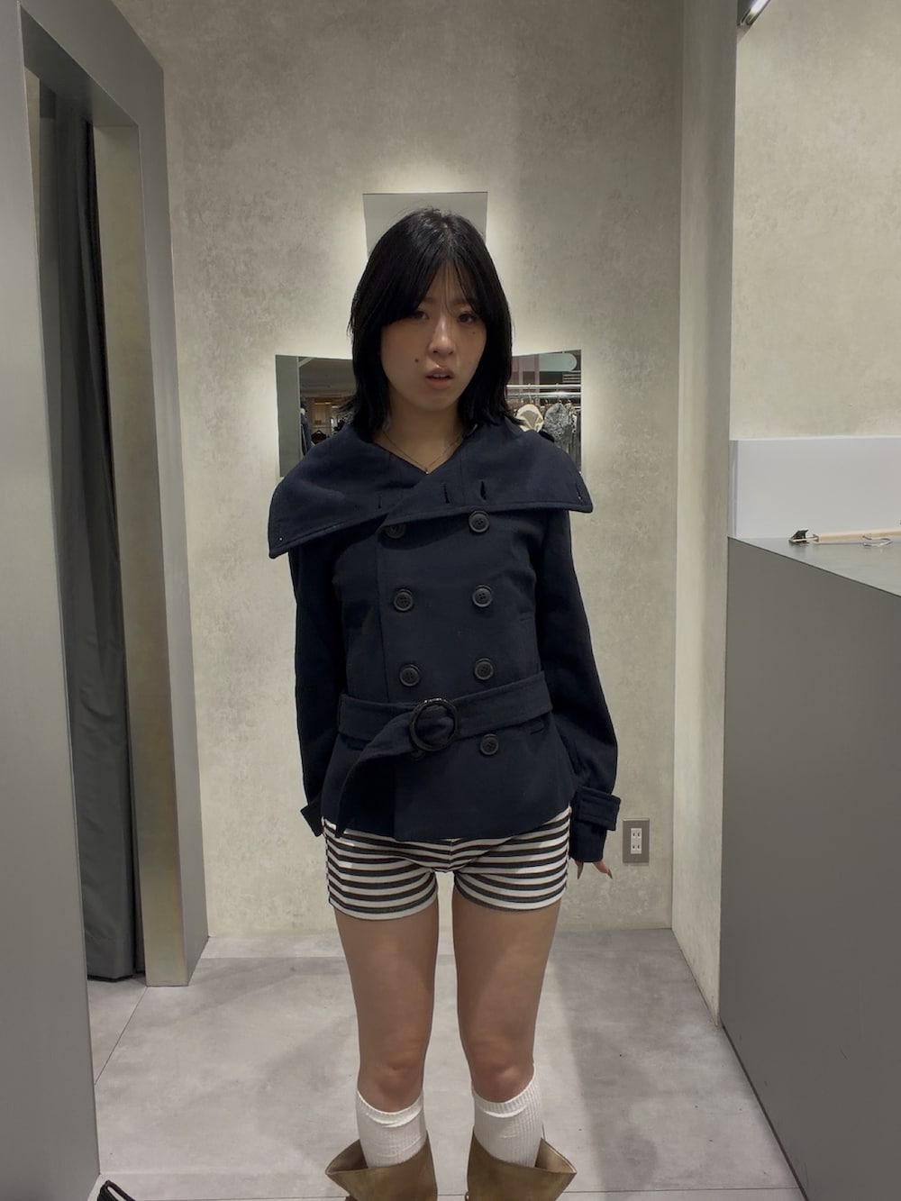 ブルー系のピーコート、ブラック系のパンツを着用したレディースの秋コーディネートの3枚目の写真