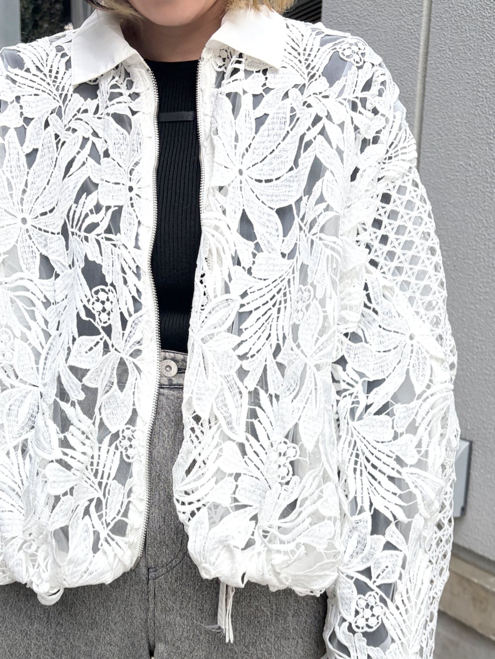 ホワイト系のブルゾンを着用したレディースの冬コーディネートの2枚目の写真