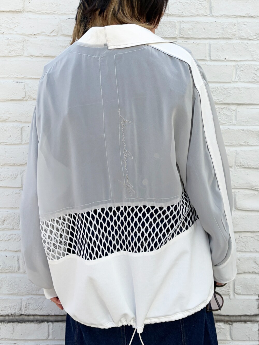 ホワイト系のブルゾンを着用したレディースの春コーディネートの3枚目の写真