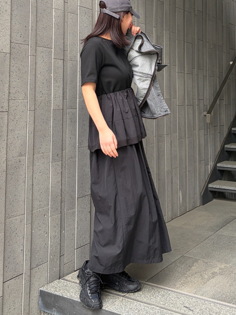 ブラック系のワンピースを着用したレディースの春コーディネートの2枚目の写真