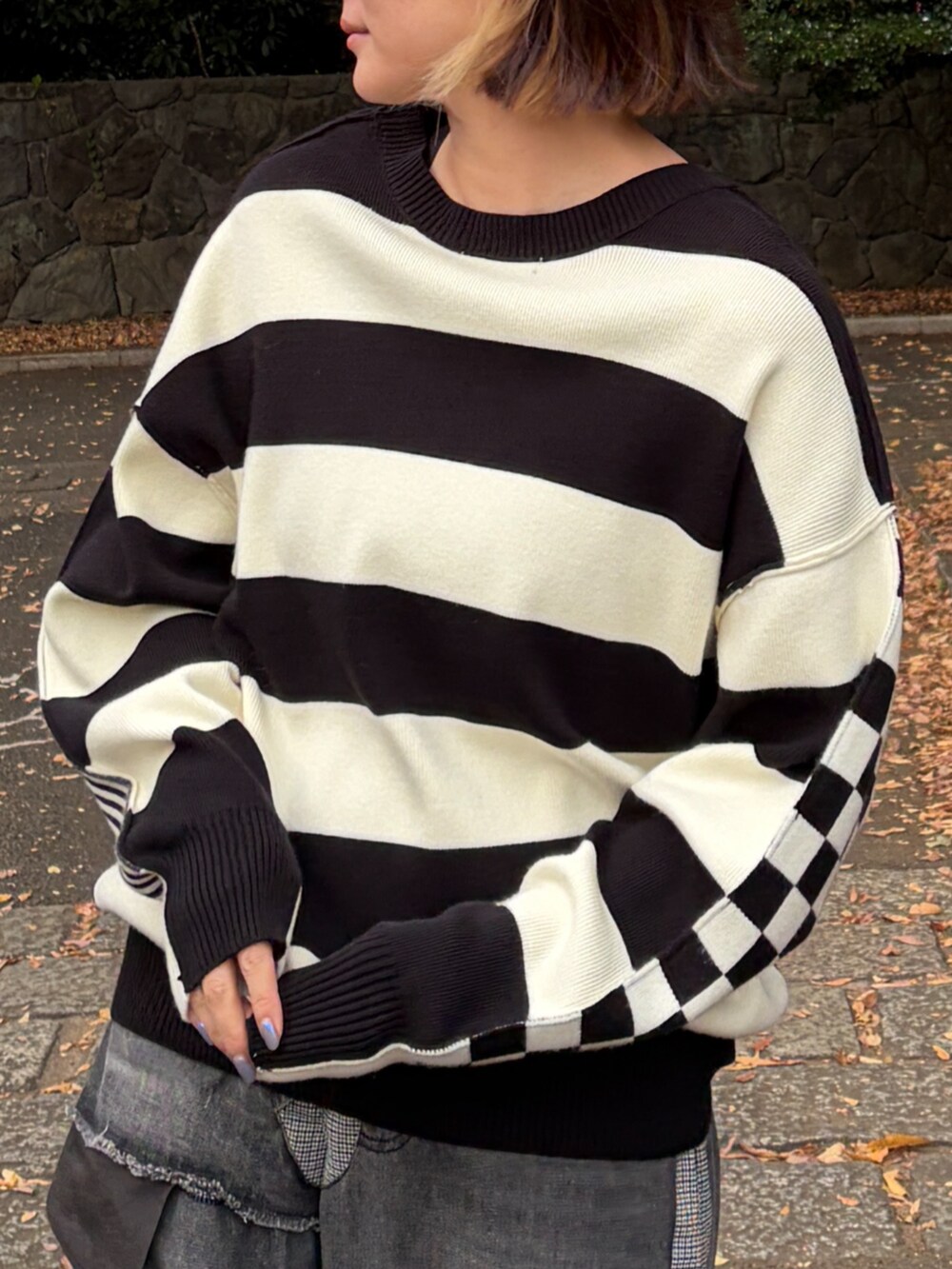 ブラック系のニット/セーター、グレー系のデニムパンツを着用したレディースの秋コーディネートの4枚目の写真