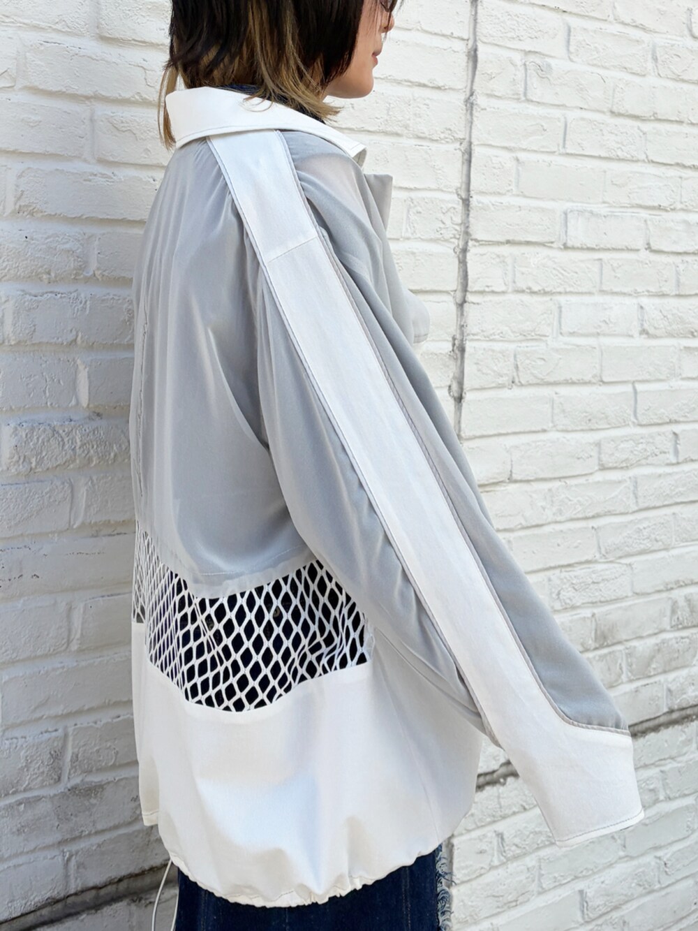 ホワイト系のブルゾンを着用したレディースの春コーディネートの2枚目の写真