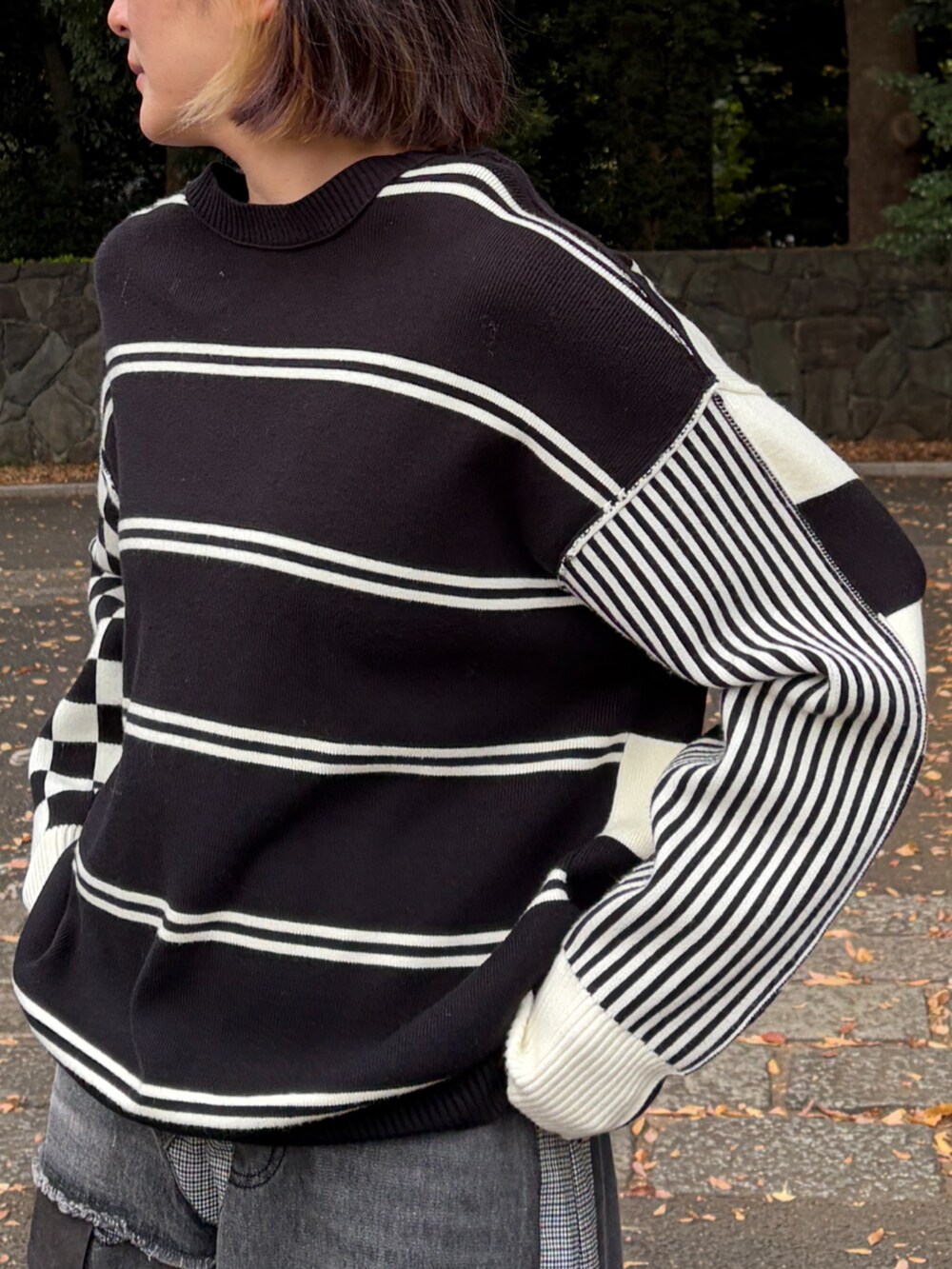 ブラック系のニット/セーター、グレー系のデニムパンツを着用したレディースの秋コーディネートの3枚目の写真