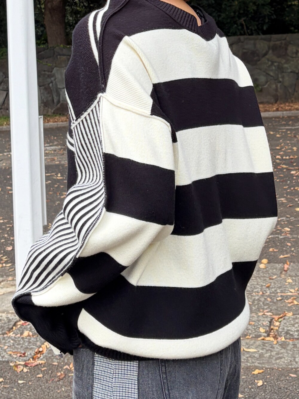 ブラック系のニット/セーター、グレー系のデニムパンツを着用したレディースの秋コーディネートの5枚目の写真