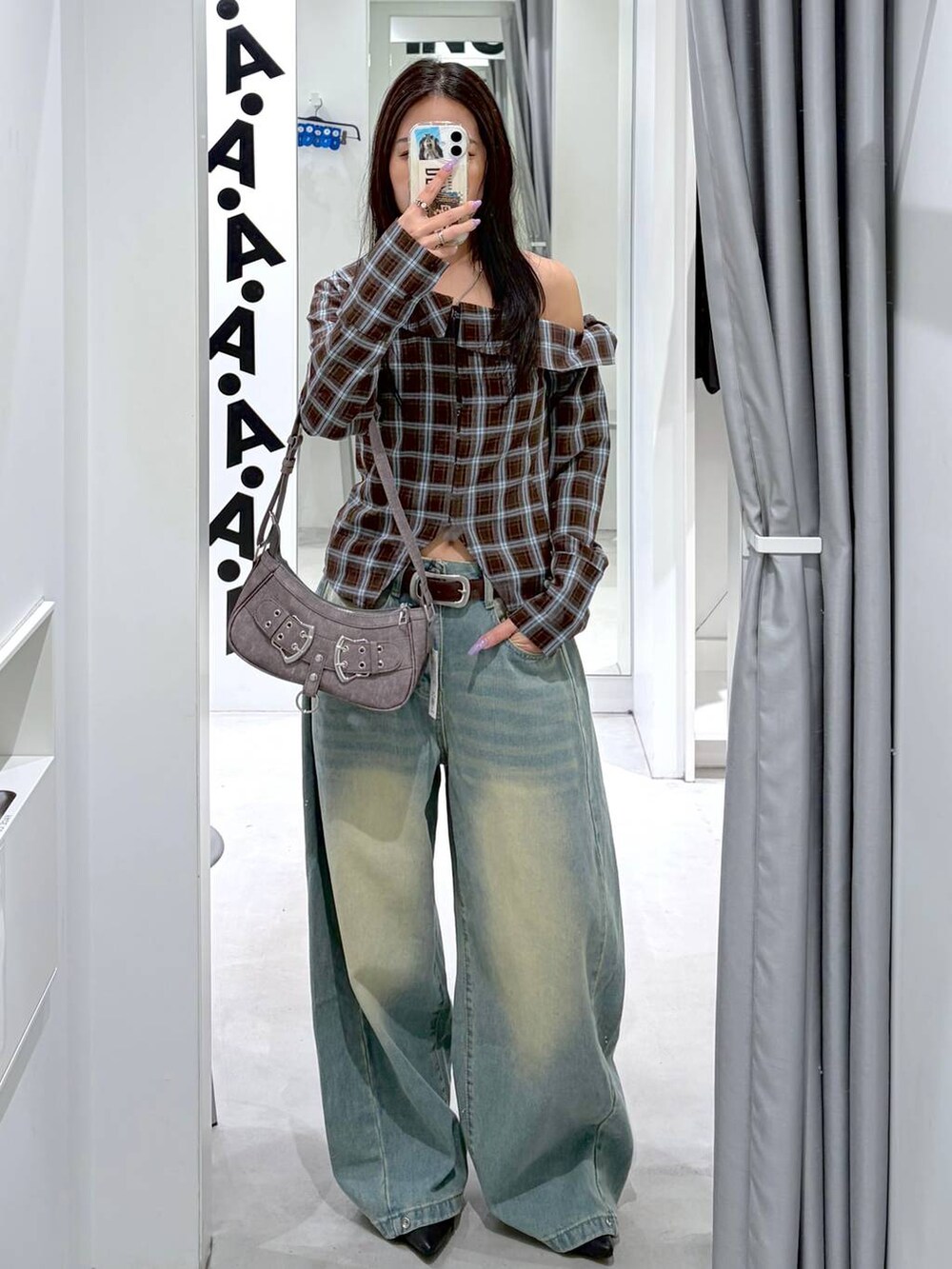 ブルー系のデニムパンツ、ブラック系のパンプス、グレー系のハンドバッグを着用したレディースの春コーディネートの2枚目の写真