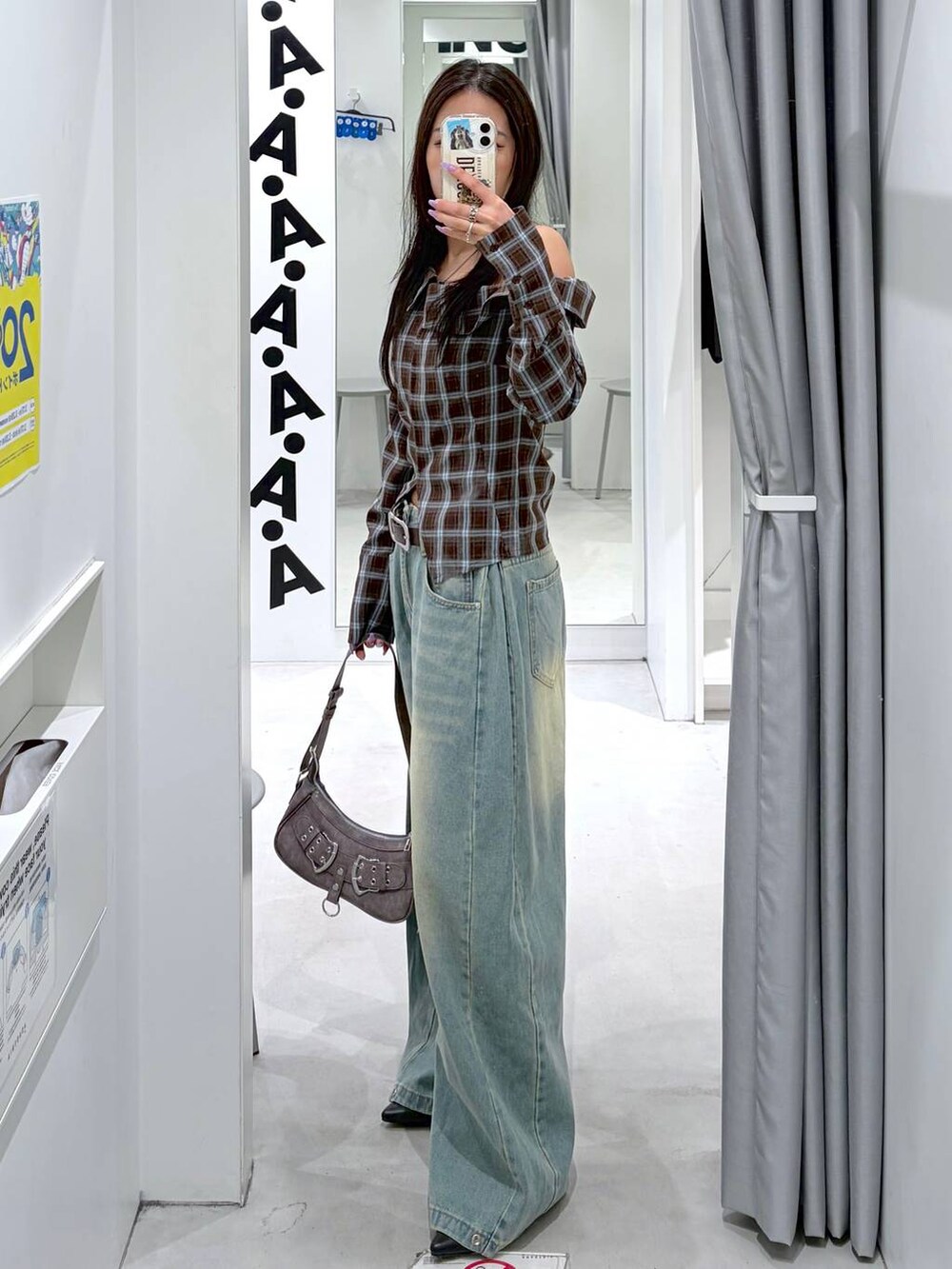 ブルー系のデニムパンツ、ブラック系のパンプス、グレー系のハンドバッグを着用したレディースの春コーディネートの3枚目の写真