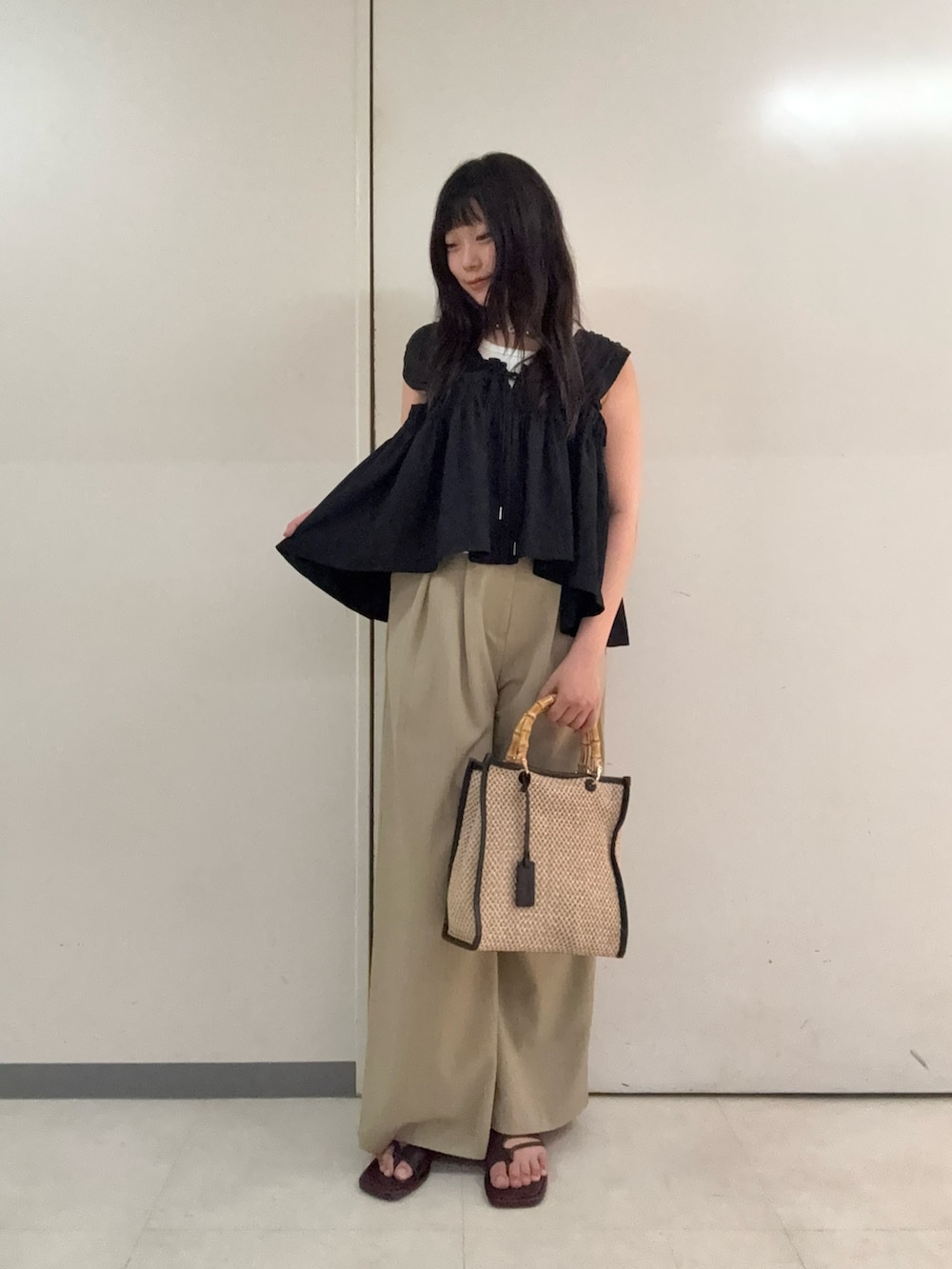 ブラック系のシャツ/ブラウス、ベージュ系のスラックス、ブラウン系のサンダルを着用したレディースの夏コーディネートの2枚目の写真