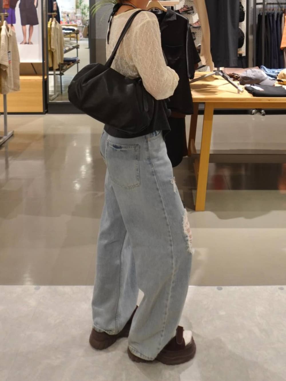 グレー系のキャミソール、ホワイト系のTシャツ/カットソー、ブルー系のデニムパンツを着用したレディースの秋コーディネートの2枚目の写真
