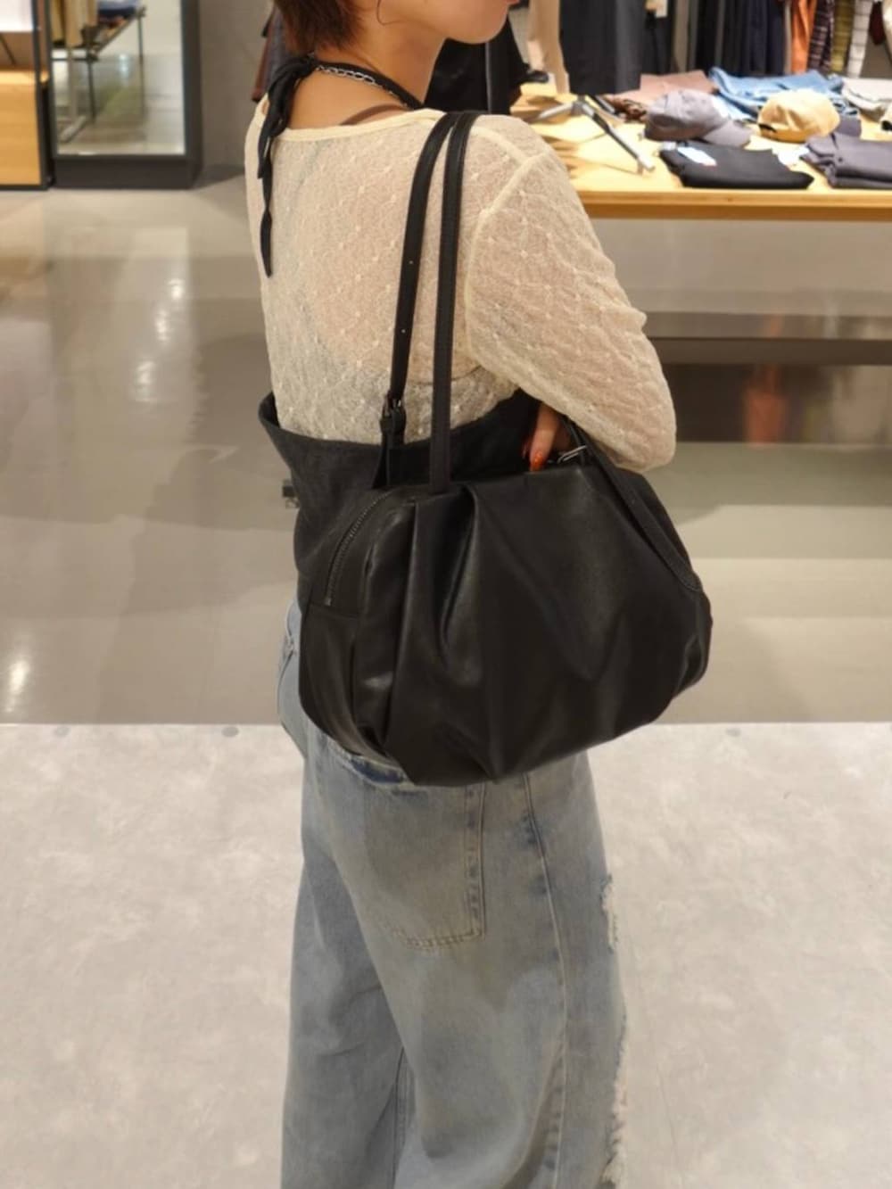 グレー系のキャミソール、ホワイト系のTシャツ/カットソー、ブルー系のデニムパンツを着用したレディースの秋コーディネートの6枚目の写真