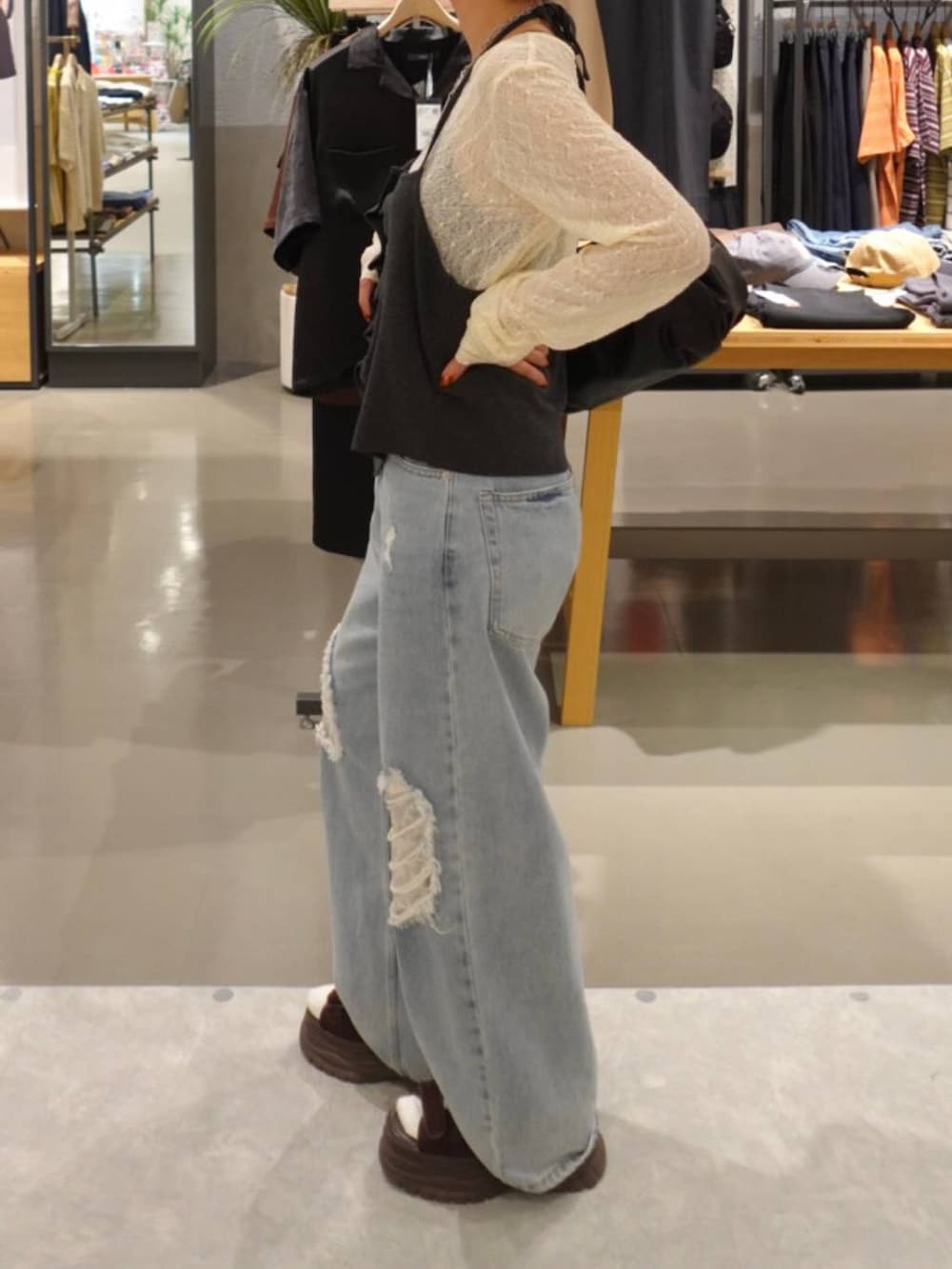 グレー系のキャミソール、ホワイト系のTシャツ/カットソー、ブルー系のデニムパンツを着用したレディースの秋コーディネートの3枚目の写真