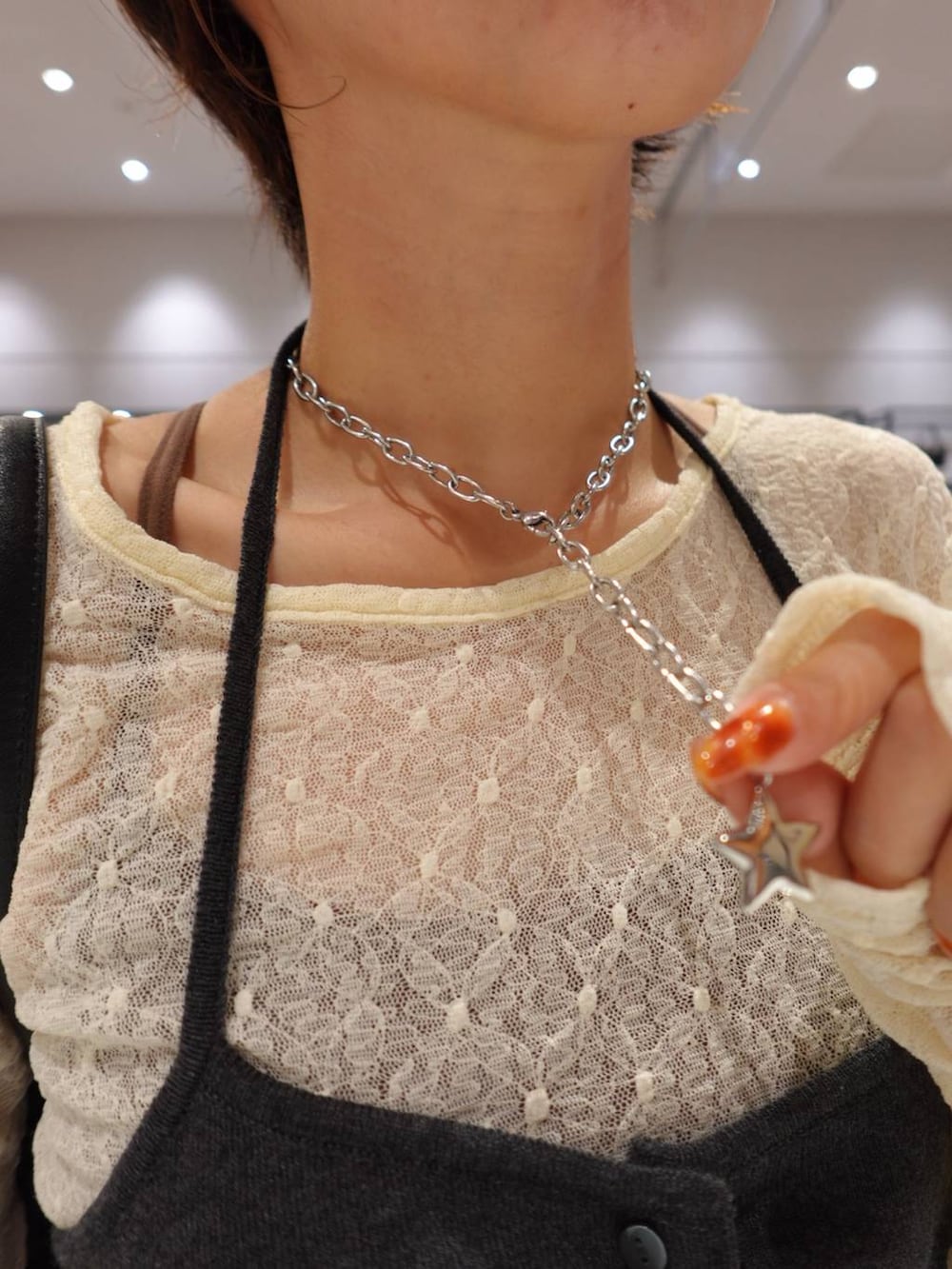 グレー系のキャミソール、ホワイト系のTシャツ/カットソー、ブルー系のデニムパンツを着用したレディースの秋コーディネートの4枚目の写真