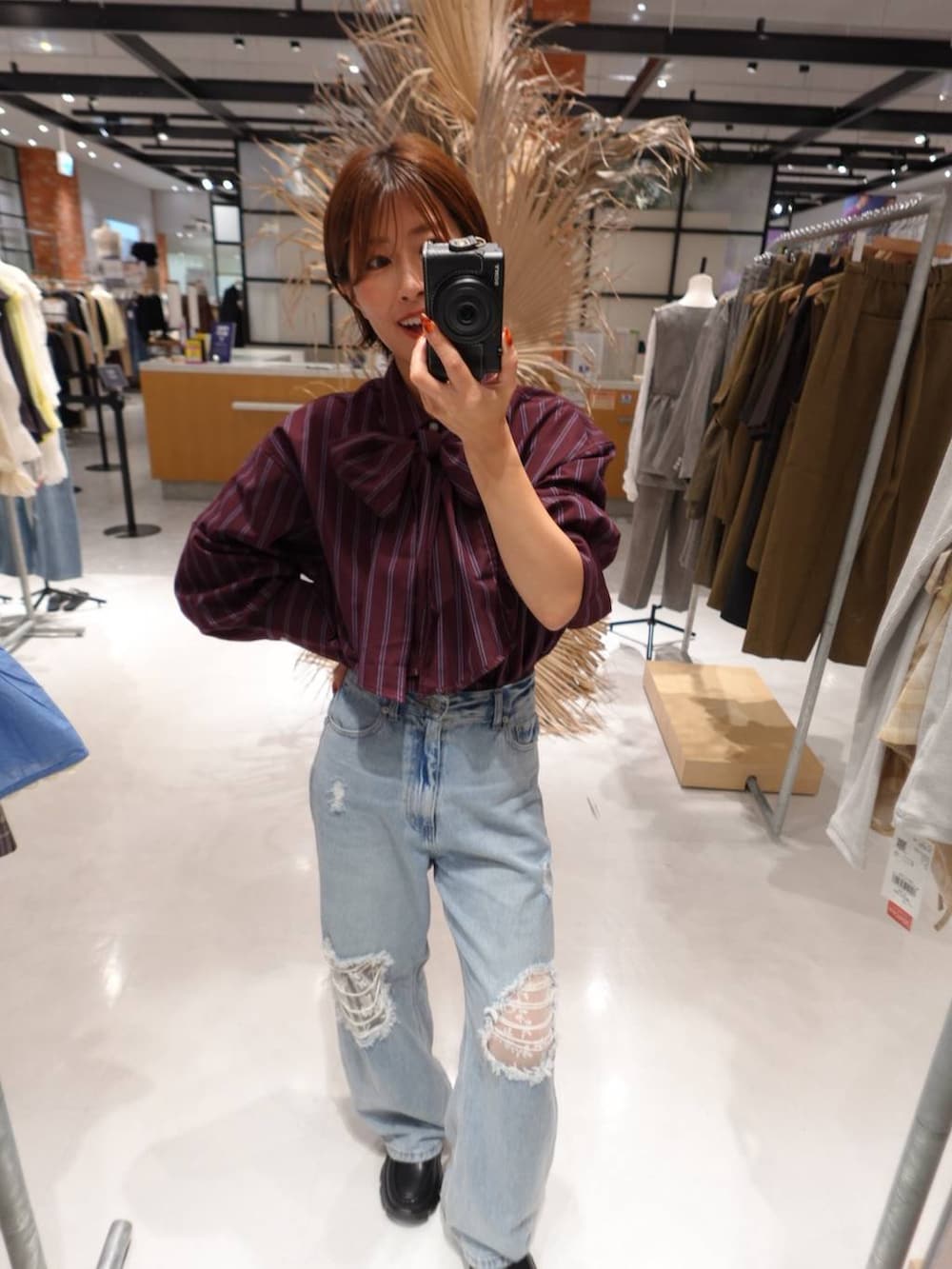 ブルー系のデニムパンツ、レッド系のシャツ/ブラウスを着用したレディースの秋コーディネートの2枚目の写真