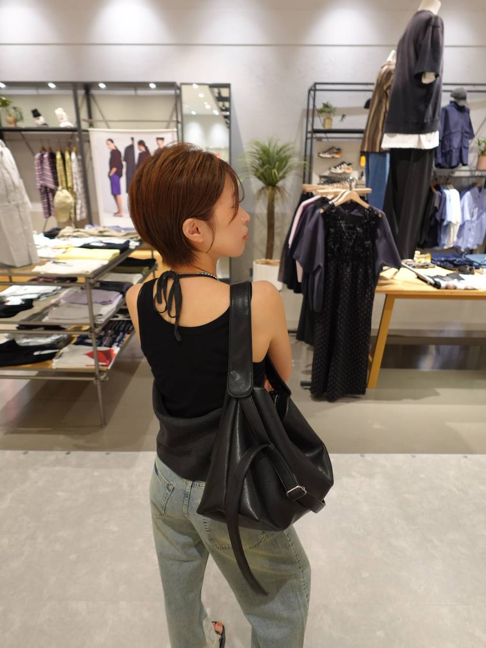 ブラック系のタンクトップ、グレー系のキャミソール、ブルー系のデニムパンツを着用したレディースの夏コーディネートの2枚目の写真