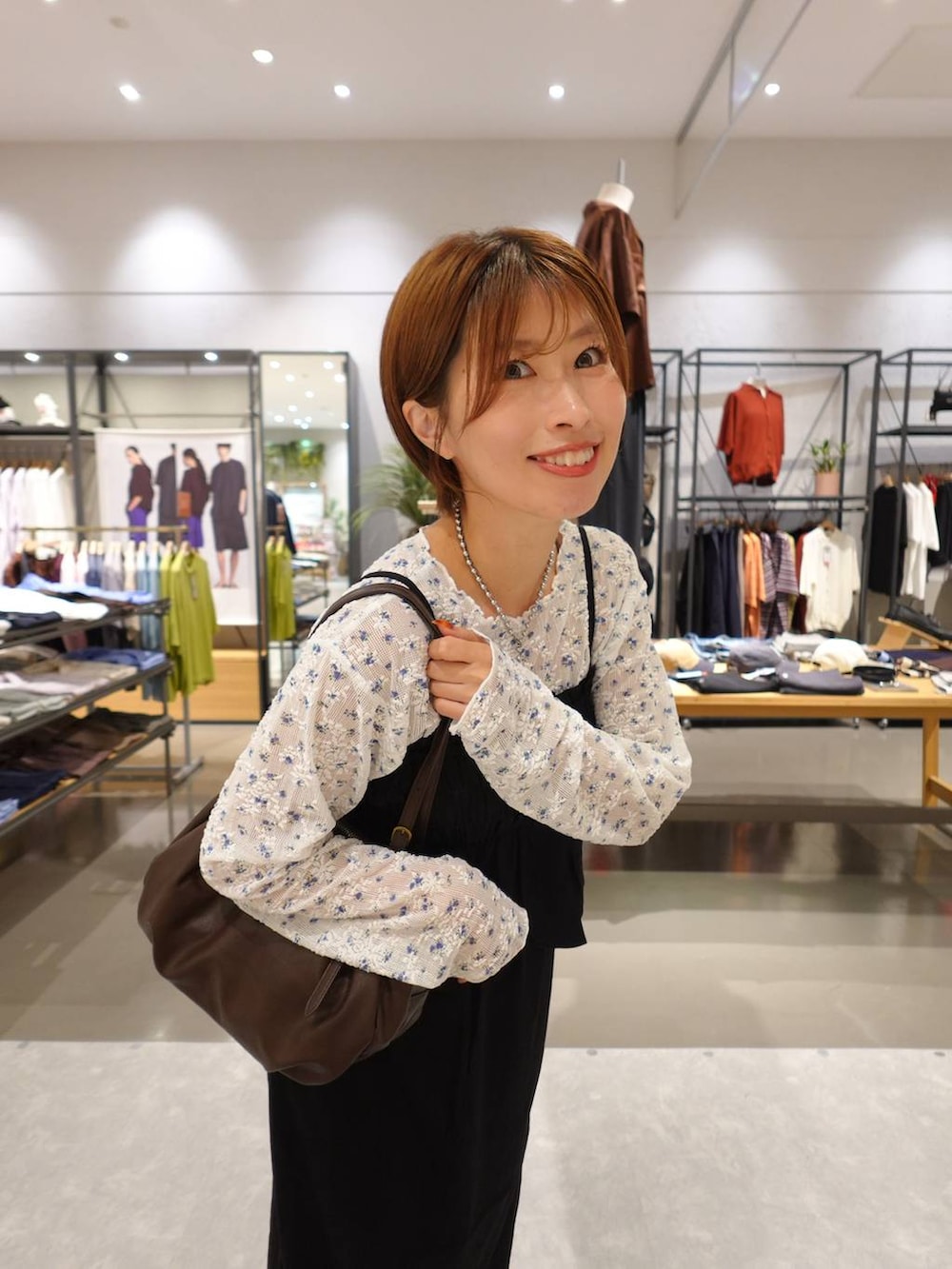 ブラウン系のブーツ、ブラウン系のボストンバッグ、ブラック系のスカートを着用したレディースの夏コーディネートの6枚目の写真