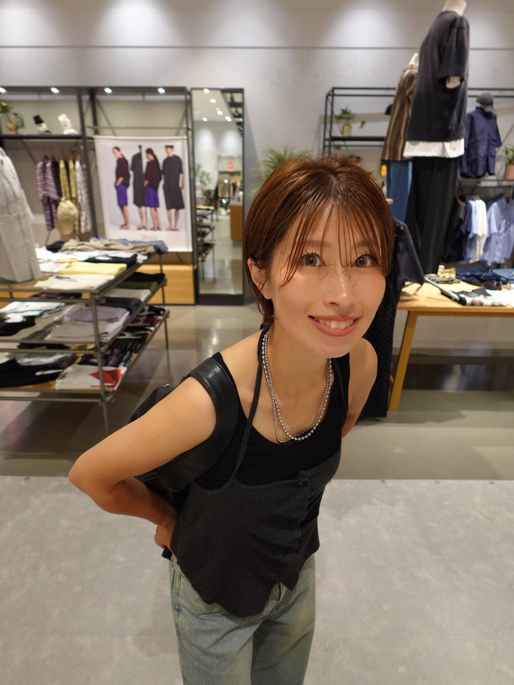 ブラック系のタンクトップ、グレー系のキャミソール、ブルー系のデニムパンツを着用したレディースの夏コーディネートの4枚目の写真