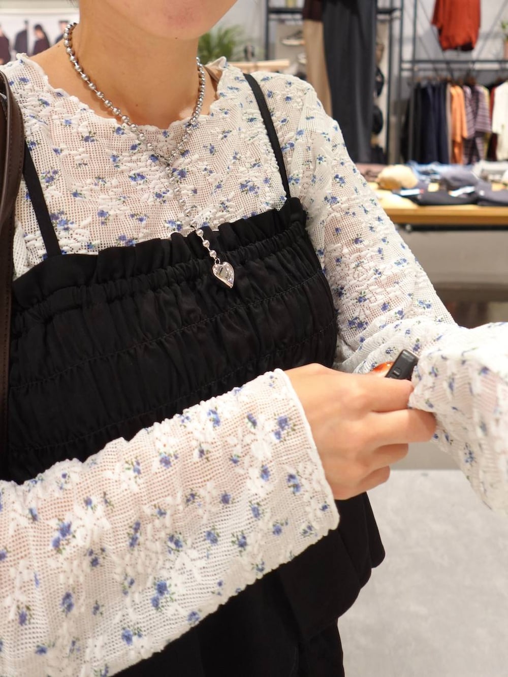ブラウン系のブーツ、ブラウン系のボストンバッグ、ブラック系のスカートを着用したレディースの夏コーディネートの5枚目の写真