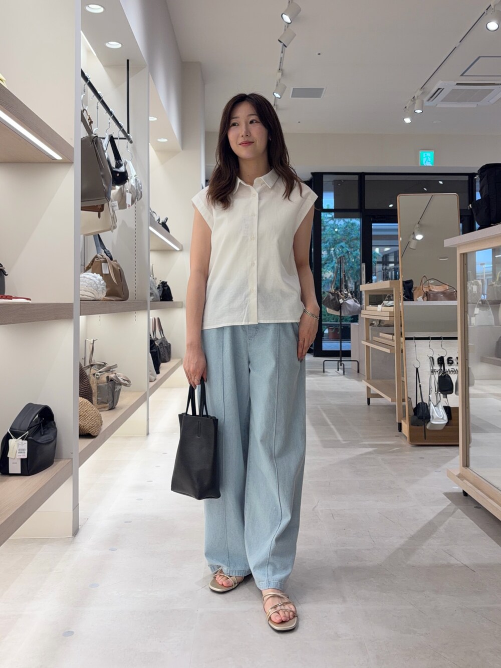 ホワイト系のシャツ/ブラウス、ブルー系のデニムパンツを着用したレディースの春コーディネートの2枚目の写真