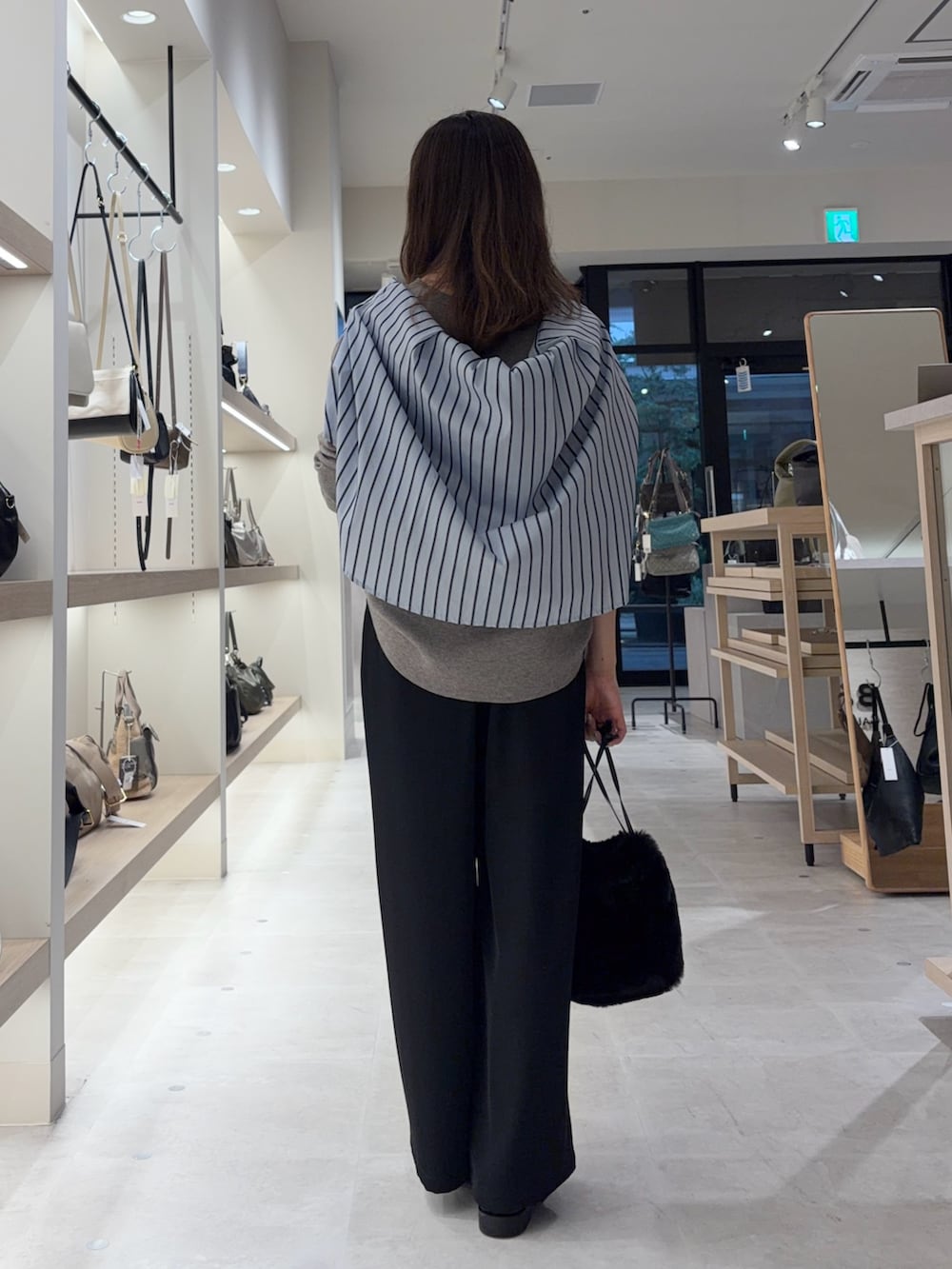 ブラック系のその他パンツ、グレー系のニット/セーター、ブルー系のシャツ/ブラウスを着用したレディースの秋コーディネートの2枚目の写真