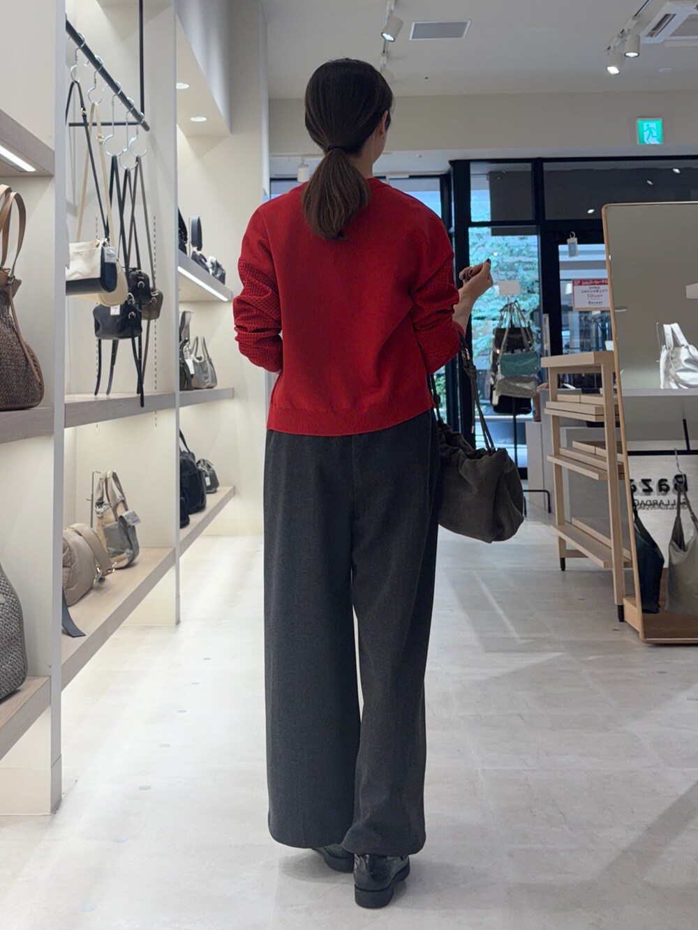 レッド系のニット/セーター、グレー系のその他パンツを着用したレディースの秋コーディネートの2枚目の写真