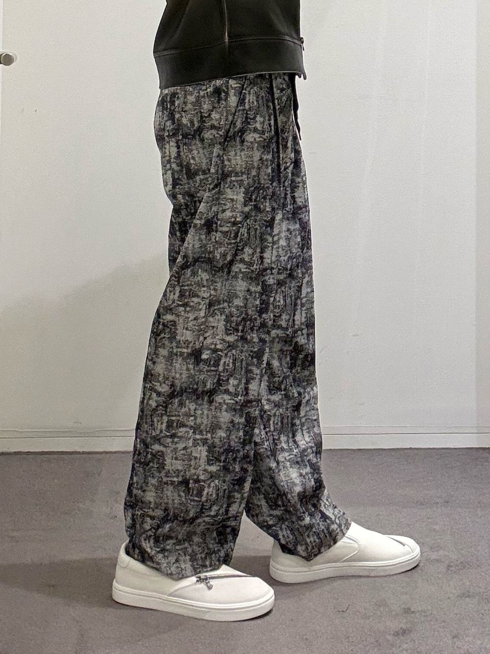 ホワイト系のスニーカー、ブラック系のその他パンツ、ホワイト系のTシャツ/カットソーを着用したメンズの春コーディネートの7枚目の写真