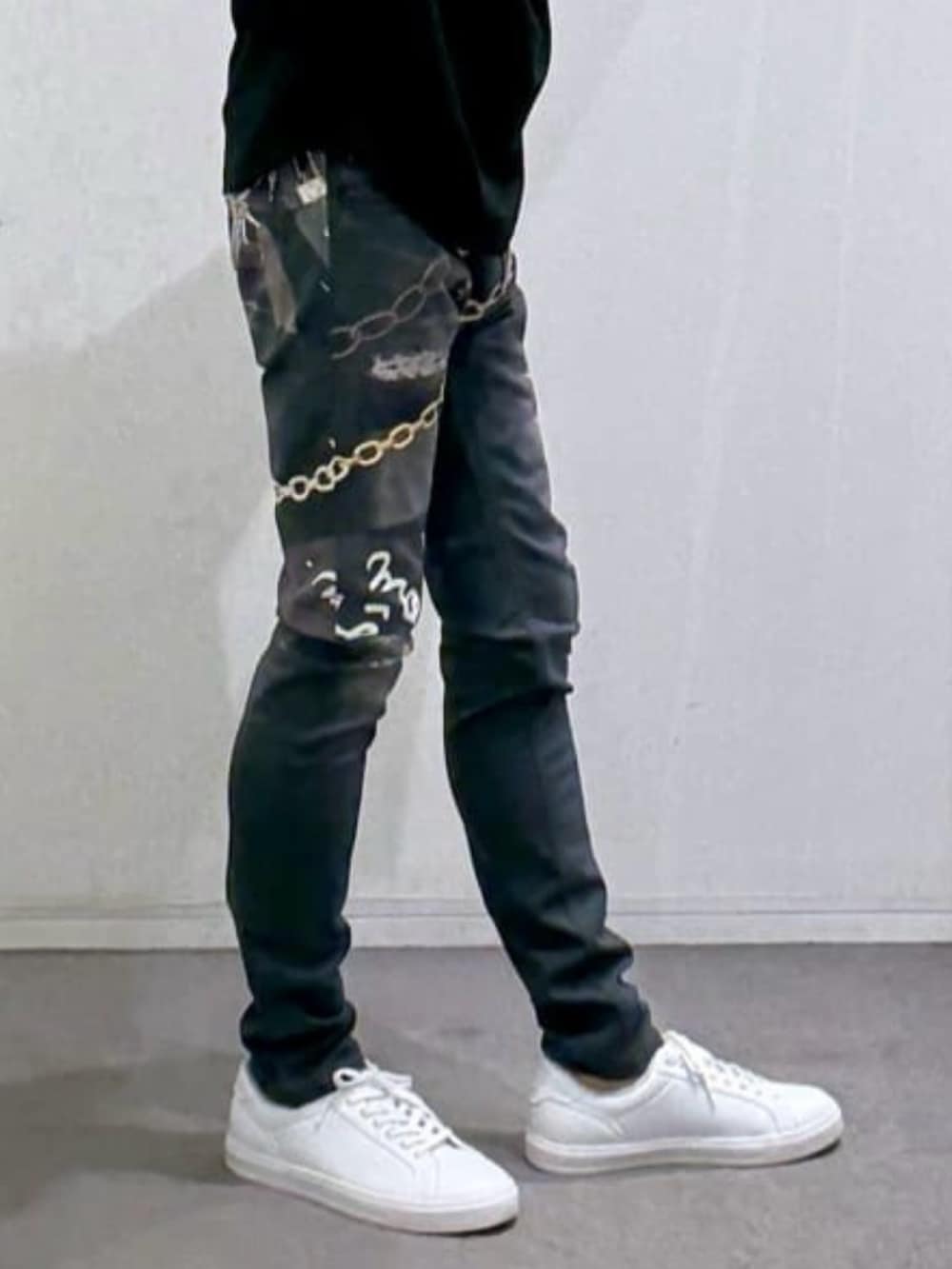 ブラック系のTシャツ/カットソー、ホワイト系のスニーカー、ブラック系のデニムパンツを着用したメンズの春コーディネートの9枚目の写真