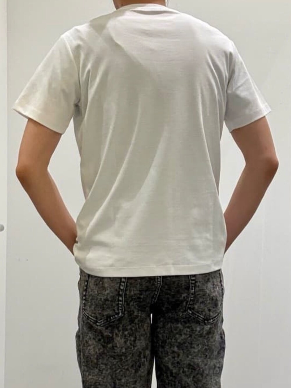 ホワイト系のスニーカー、ホワイト系のTシャツ/カットソー、ブラック系のデニムパンツを着用したメンズの夏コーディネートの6枚目の写真