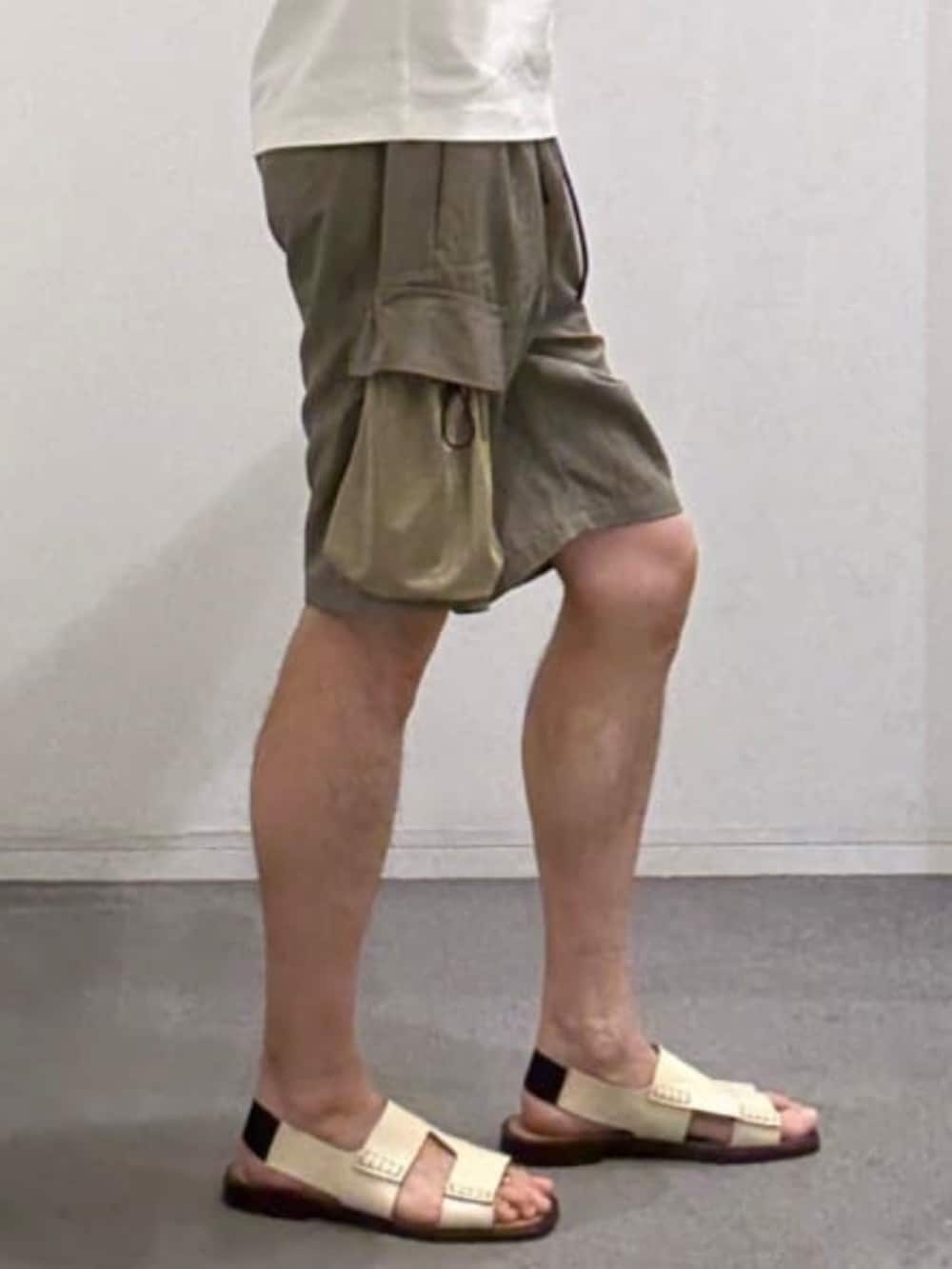 ホワイト系のTシャツ/カットソー、グリーン系のカーゴパンツ、ベージュ系のサンダルを着用したメンズの夏コーディネートの9枚目の写真