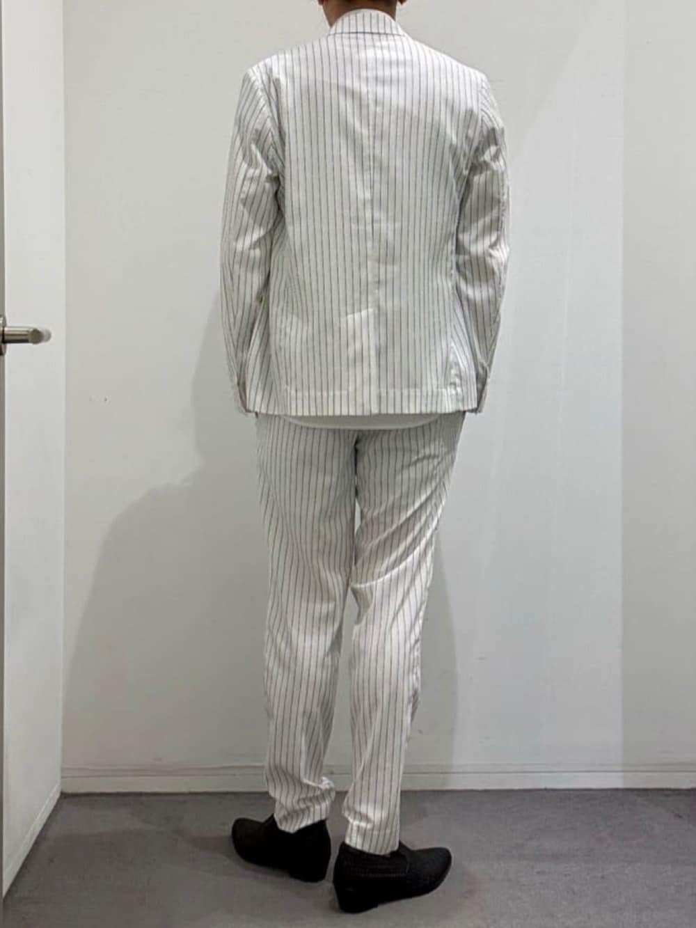 ブラック系のスリッポン、ホワイト系のスラックス、ホワイト系のシャツ/ブラウスを着用したメンズの夏コーディネートの3枚目の写真