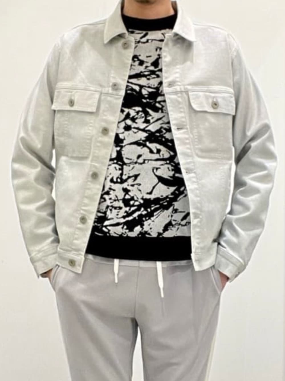 シルバー系のデニムジャケット、ブラック系のニット/セーター、グレー系のスウェットパンツを着用したメンズの夏コーディネートの7枚目の写真