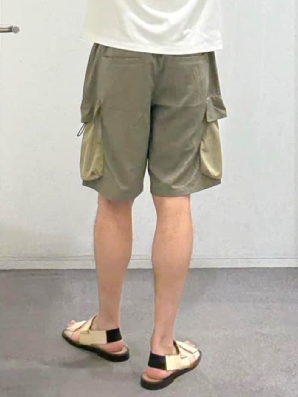ホワイト系のTシャツ/カットソー、グリーン系のカーゴパンツ、ベージュ系のサンダルを着用したメンズの夏コーディネートの10枚目の写真