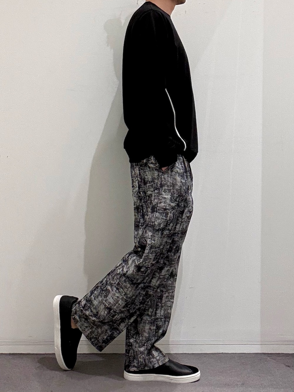 ブラック系のスニーカー、ブラック系のTシャツ/カットソー、ブラック系のその他パンツを着用したメンズの春コーディネートの2枚目の写真
