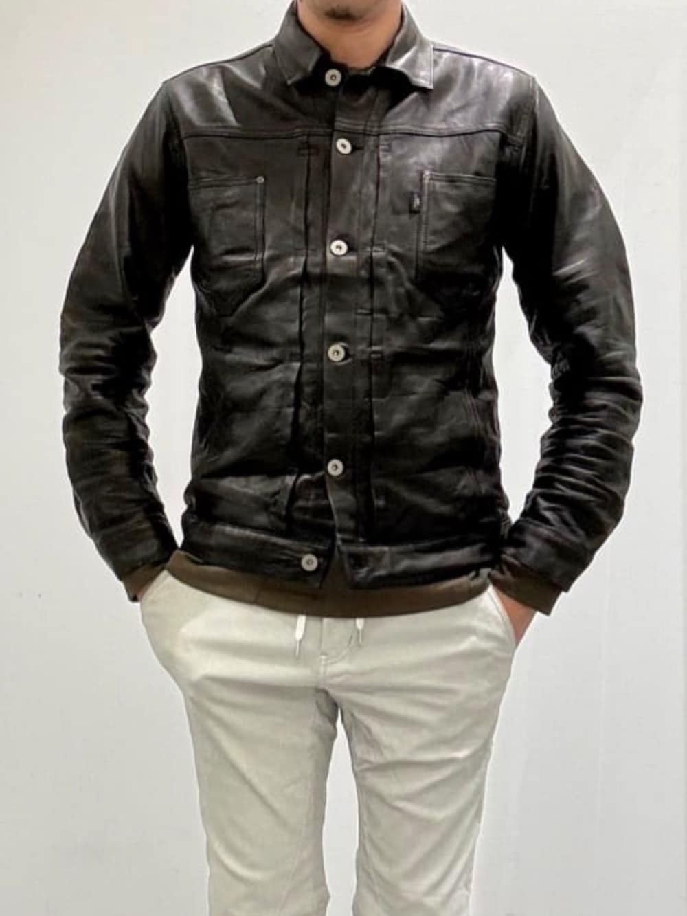 グレー系のチェスターコート、ブラック系のライダースジャケット、グリーン系のTシャツ/カットソーを着用したメンズの秋コーディネートの4枚目の写真