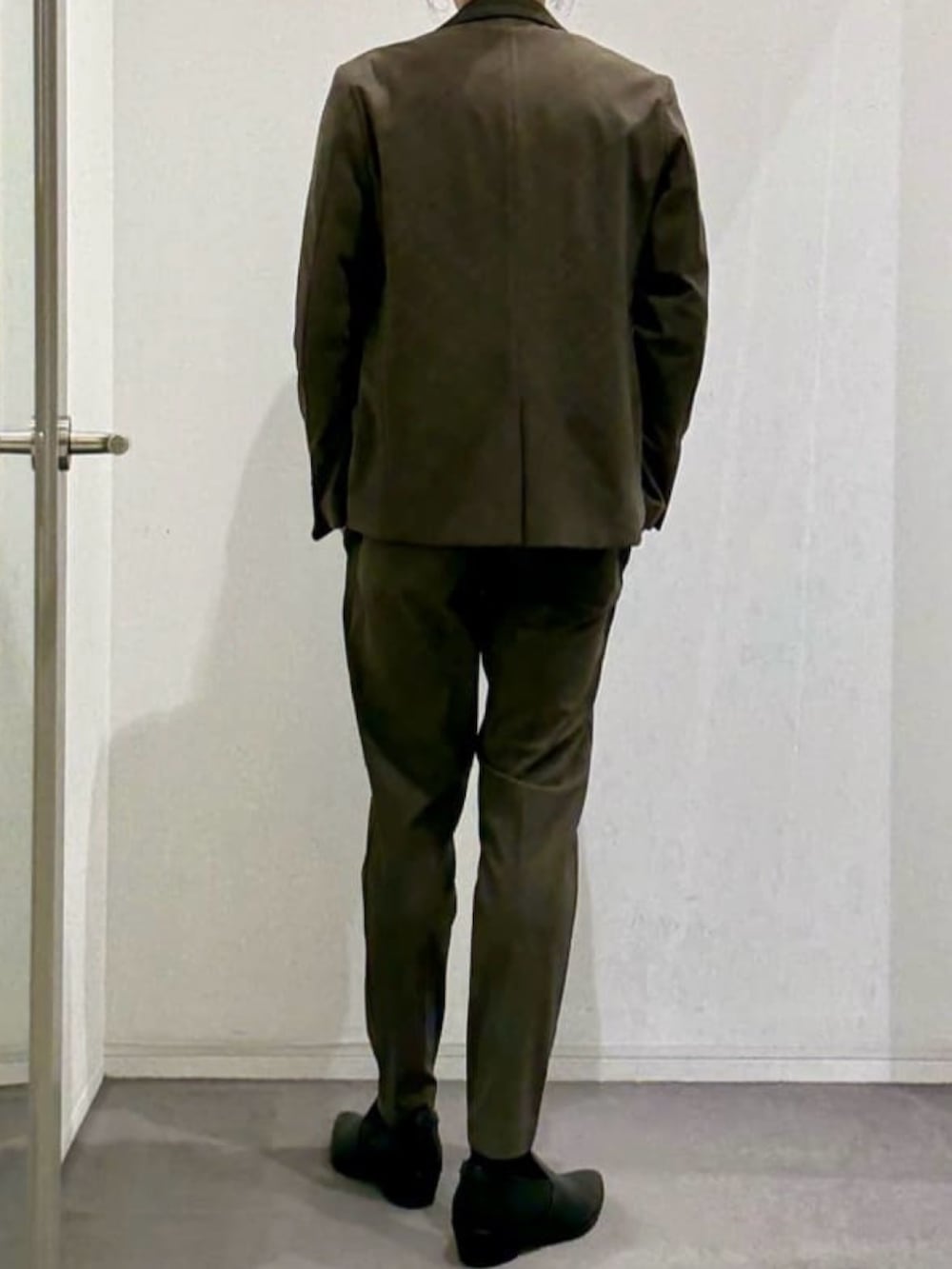 ブラック系のスリッポン、グリーン系のスラックス、ブラック系のTシャツ/カットソーを着用したメンズの春コーディネートの3枚目の写真