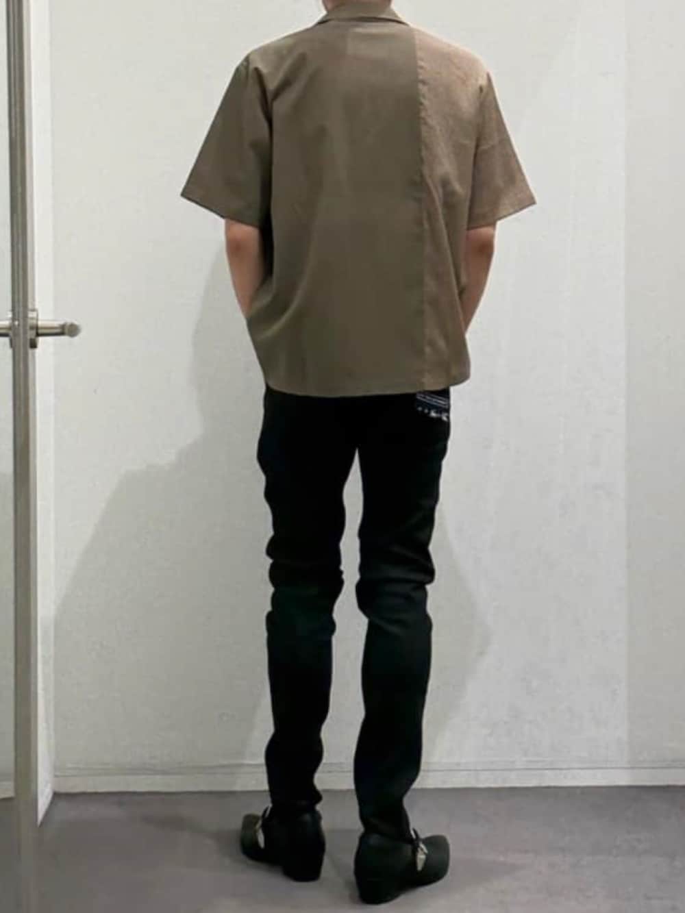 ブラック系のデニムパンツ、ブラック系のスリッポン、ブラック系のTシャツ/カットソーを着用したメンズの夏コーディネートの3枚目の写真