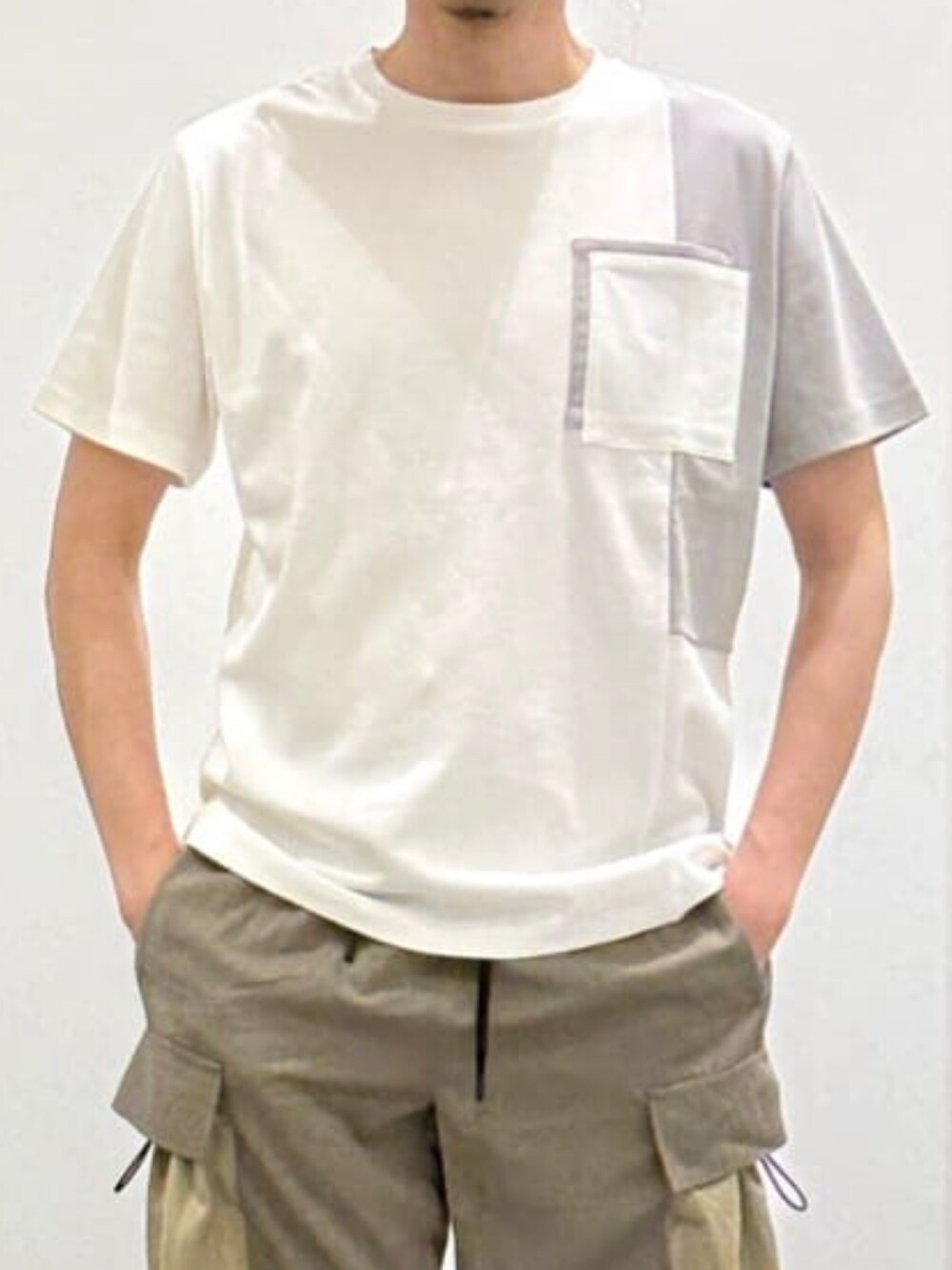 ホワイト系のTシャツ/カットソー、グリーン系のカーゴパンツ、ベージュ系のサンダルを着用したメンズの夏コーディネートの6枚目の写真