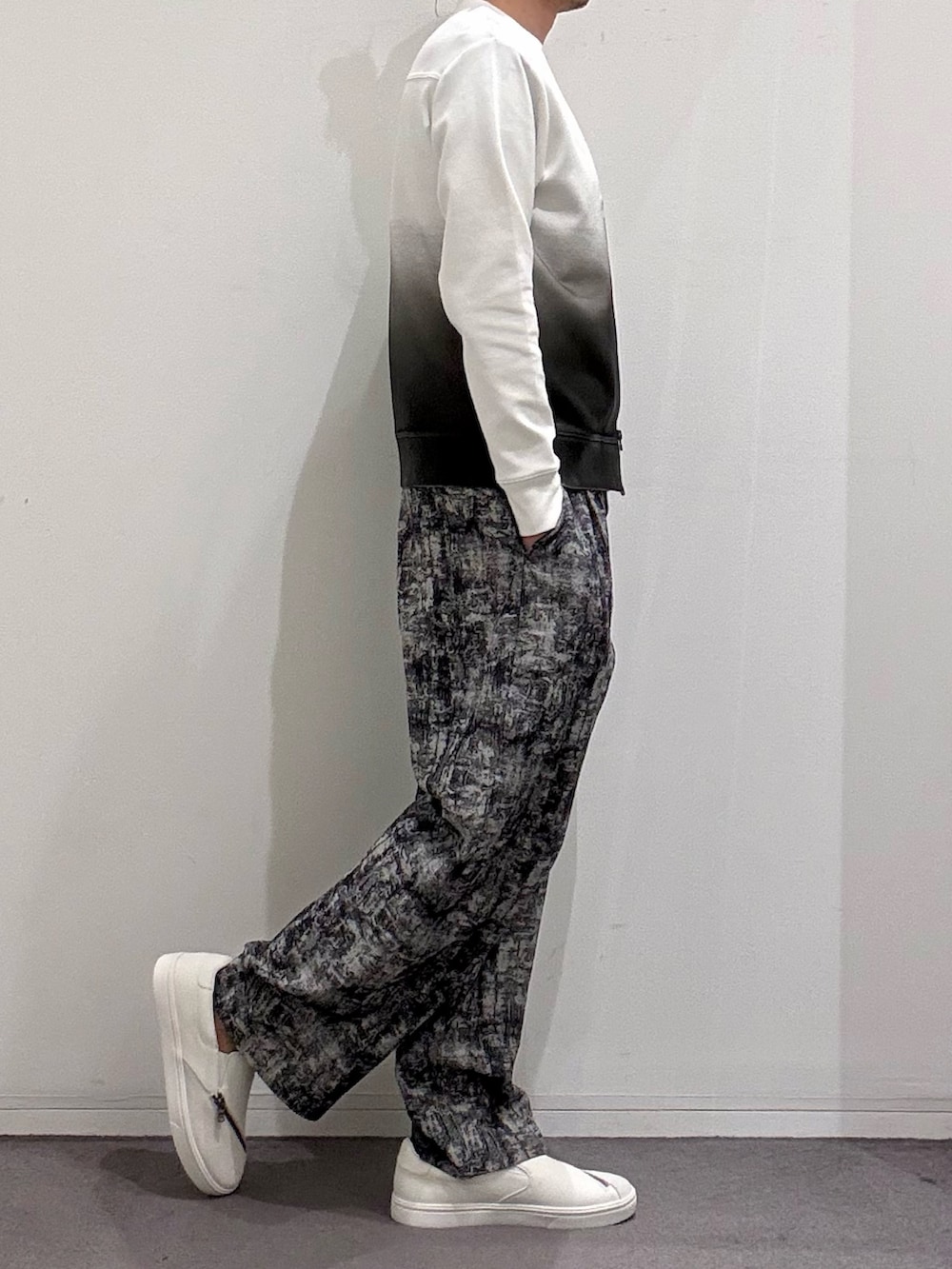 ホワイト系のスニーカー、ブラック系のその他パンツ、ホワイト系のTシャツ/カットソーを着用したメンズの春コーディネートの2枚目の写真