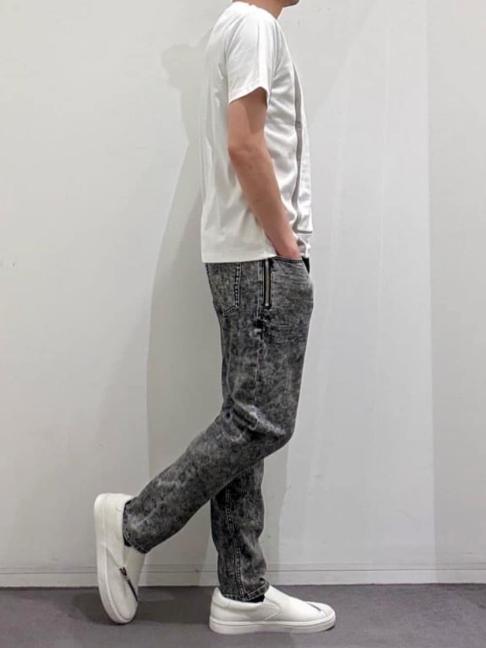 ホワイト系のスニーカー、ホワイト系のTシャツ/カットソー、ブラック系のデニムパンツを着用したメンズの夏コーディネートの3枚目の写真
