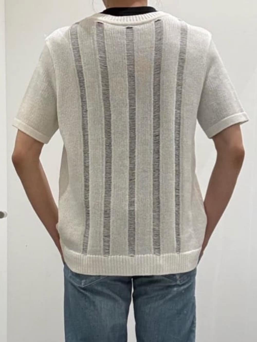ホワイト系のスニーカー、ホワイト系のニット/セーター、ブルー系のデニムパンツを着用したメンズの春コーディネートの7枚目の写真