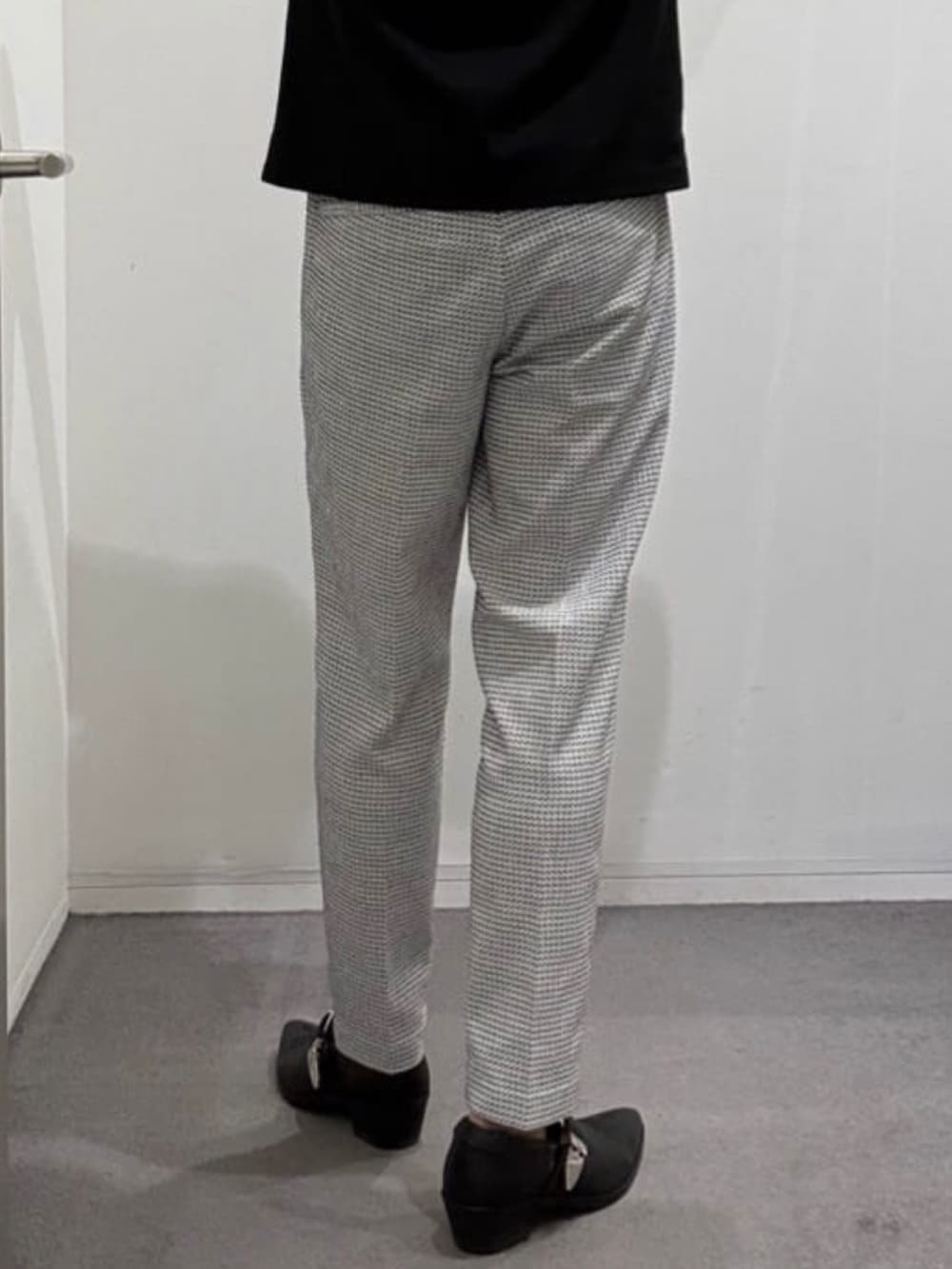 ブラック系のスリッポン、ホワイト系のスラックス、ブラック系のTシャツ/カットソーを着用したメンズの夏コーディネートの10枚目の写真