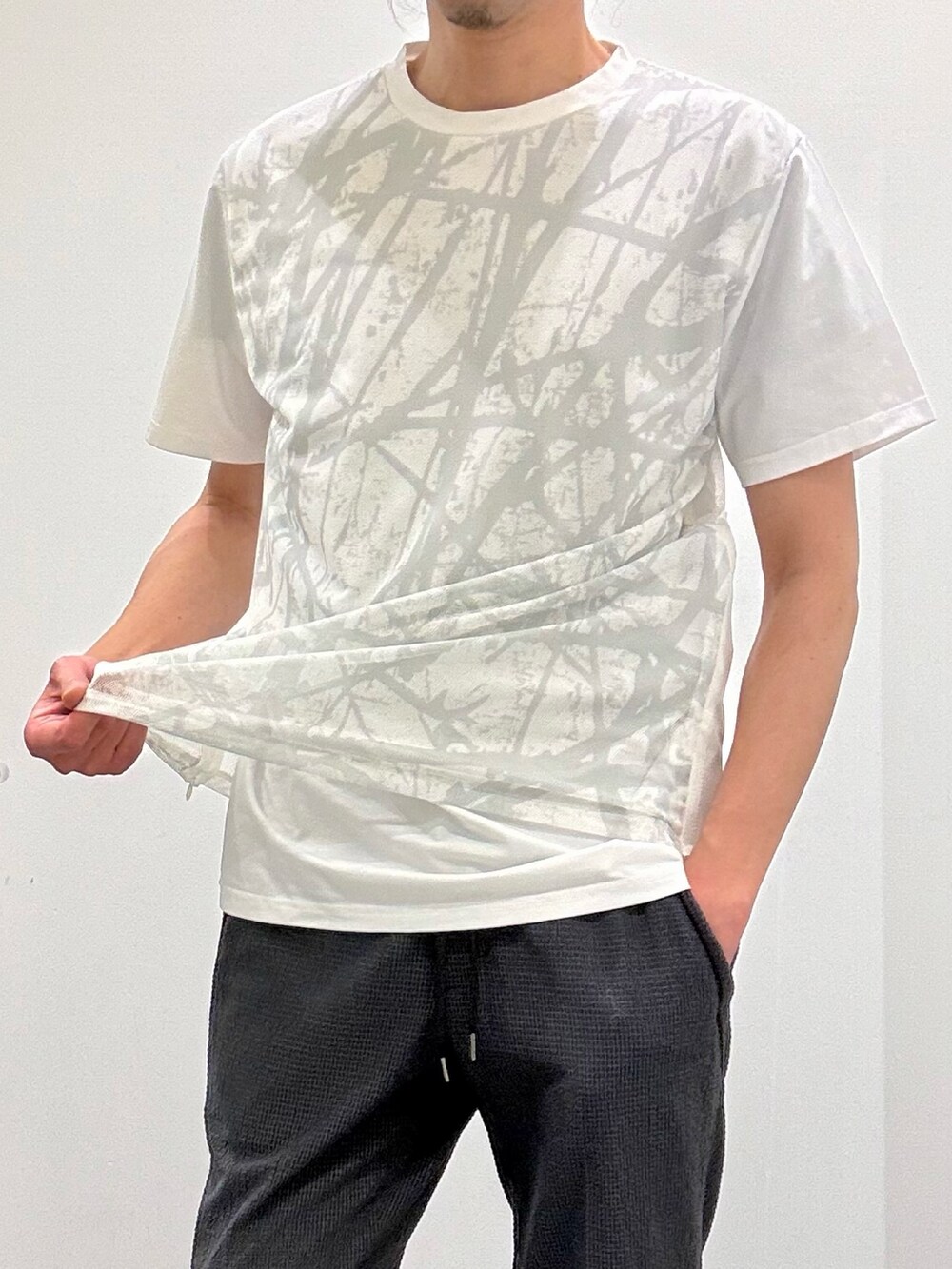 ホワイト系のTシャツ/カットソー、グレー系のテーラードジャケット、ブラック系のスリッポンを着用したメンズの春コーディネートの8枚目の写真