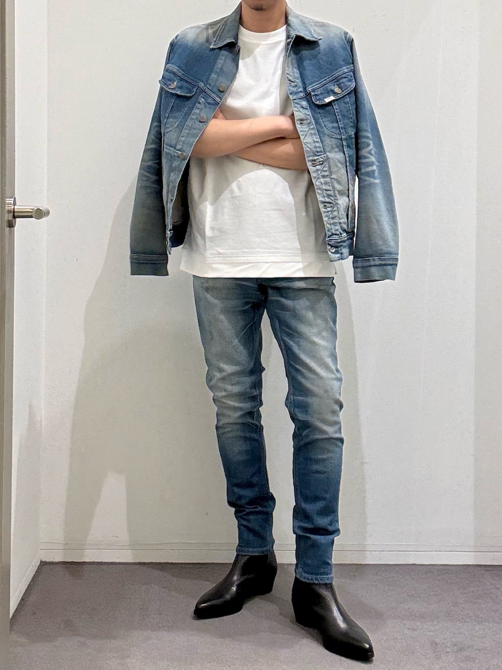 ブルー系のデニムジャケット、ブルー系のデニムパンツ、ブラック系のブーツを着用したメンズの春コーディネートの3枚目の写真