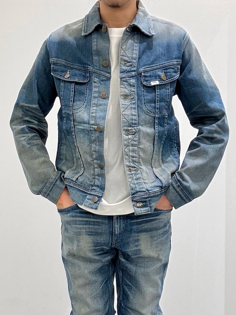 ブルー系のデニムジャケット、ブルー系のデニムパンツ、ブラック系のブーツを着用したメンズの春コーディネートの7枚目の写真